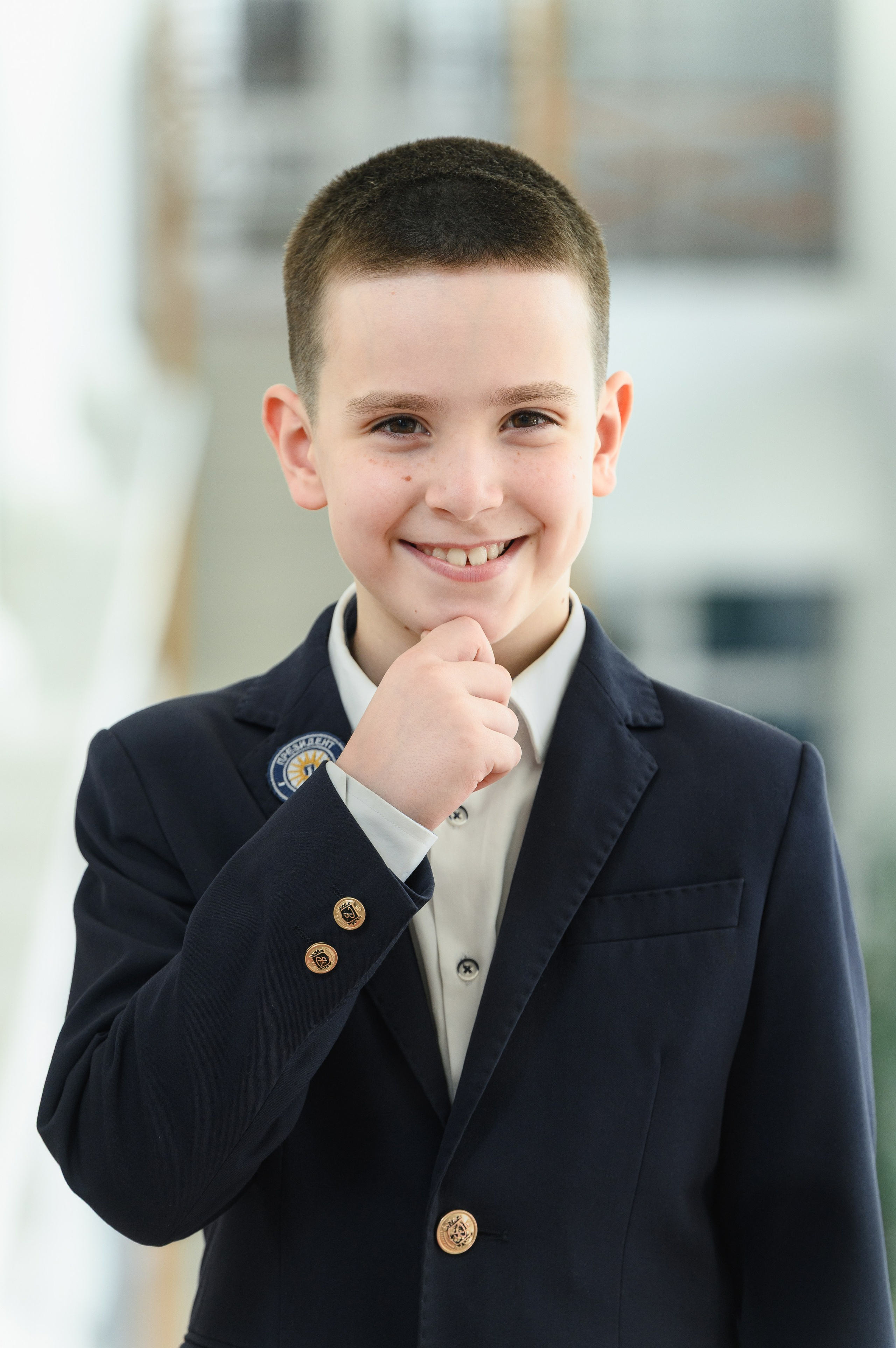 Мальчик в школьном пиджаке с задумчивым выражением лица