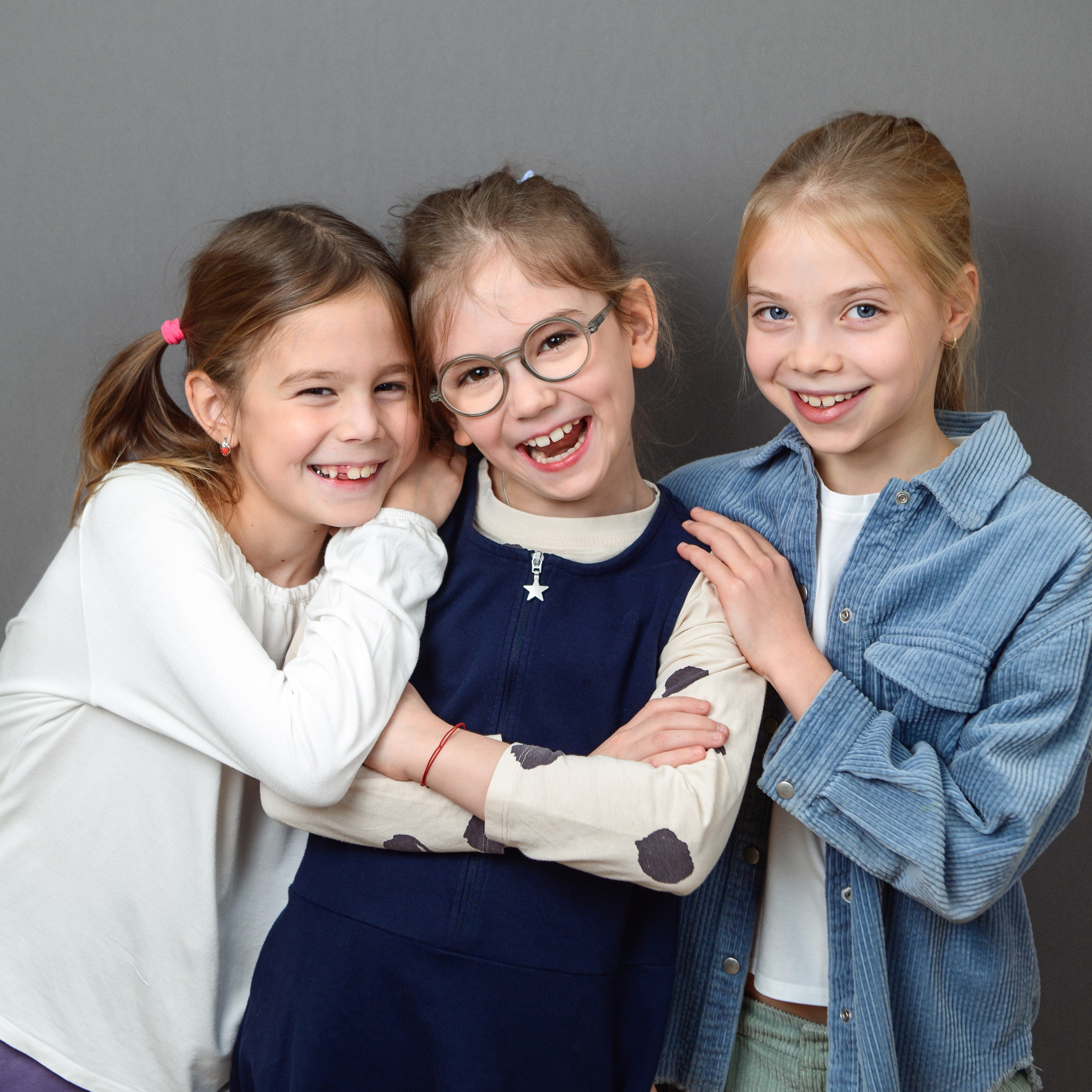 Три девочки начальной школы в дружном объятии