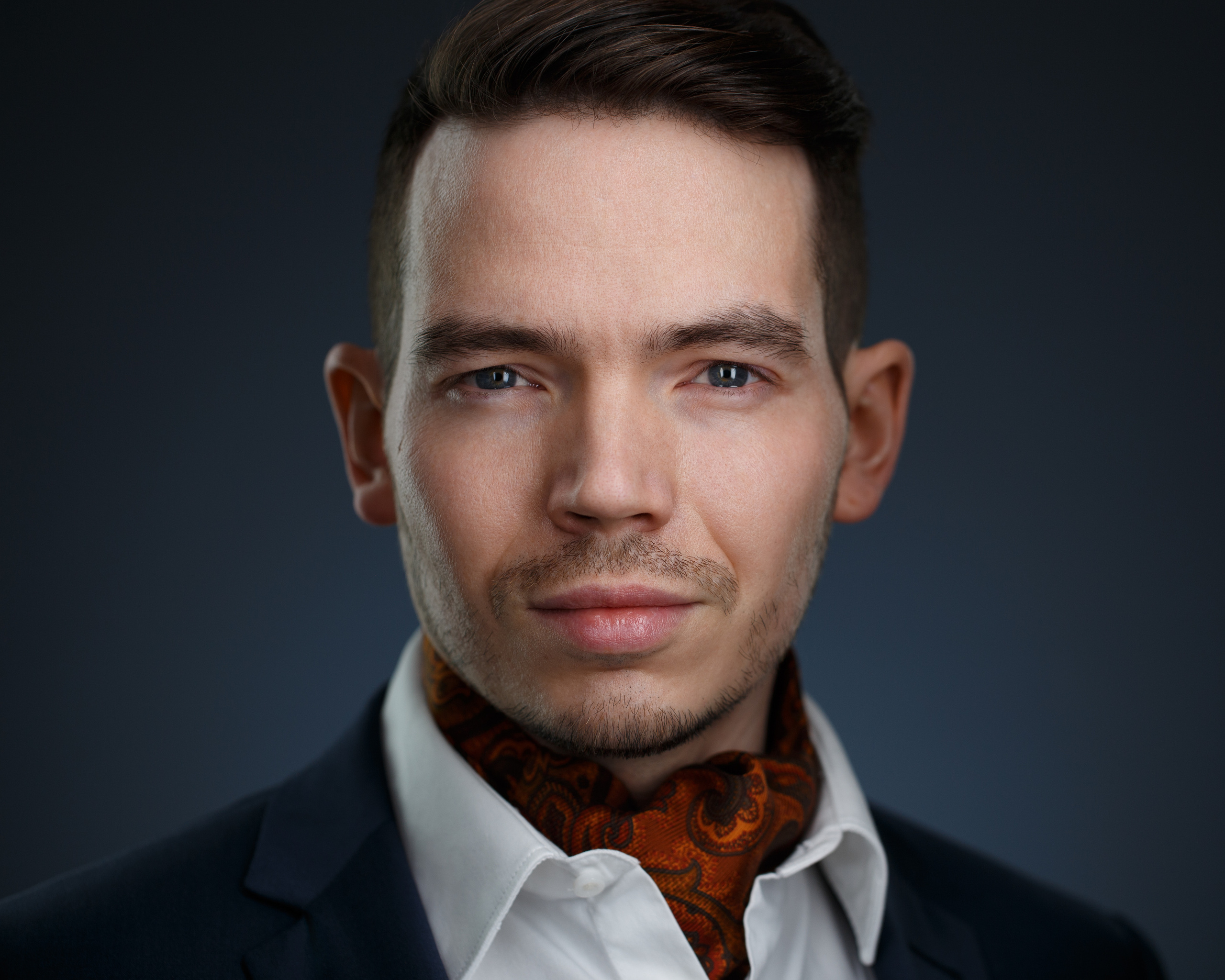 Хедшот. Стильный мужской деловой портрет крупным планом на тёмном фоне.