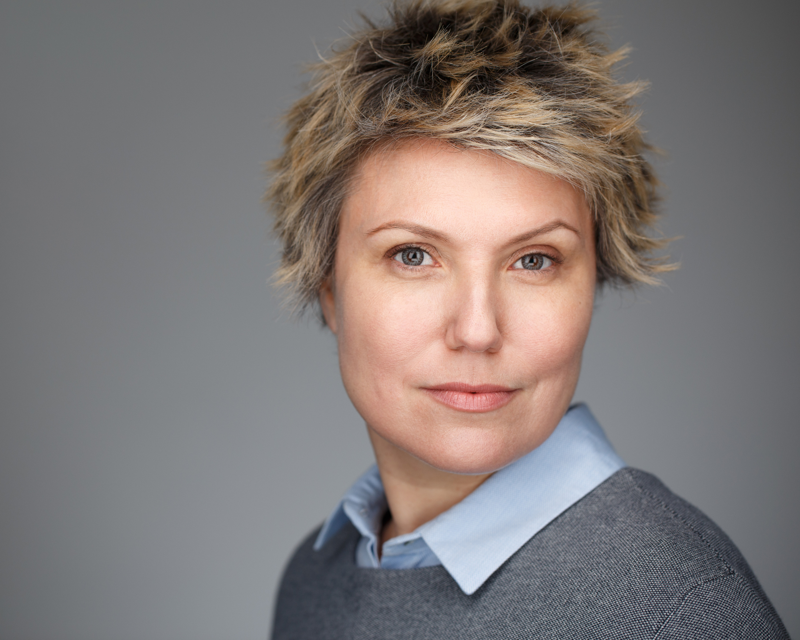 Хедшот. Бизнес-портрет женщины на сером фоне.