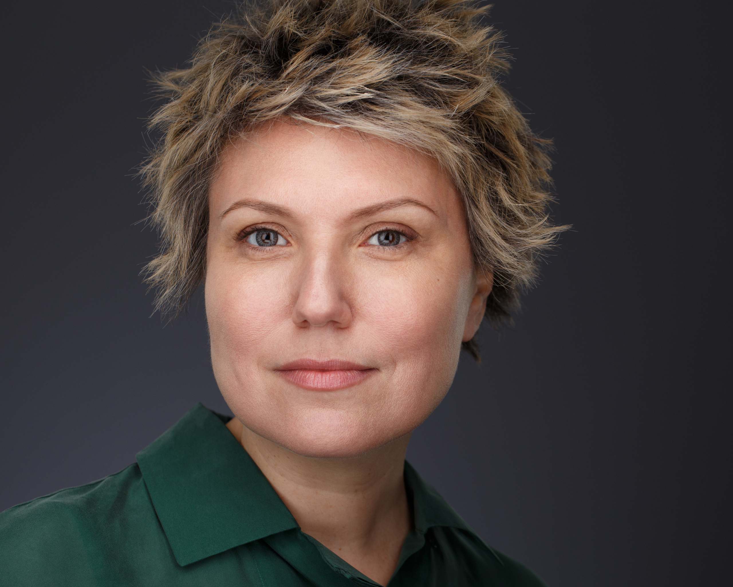 Хедшот. Крупный план. Портрет женщины на тёмном фоне транслирует уверенность и обаятельность.