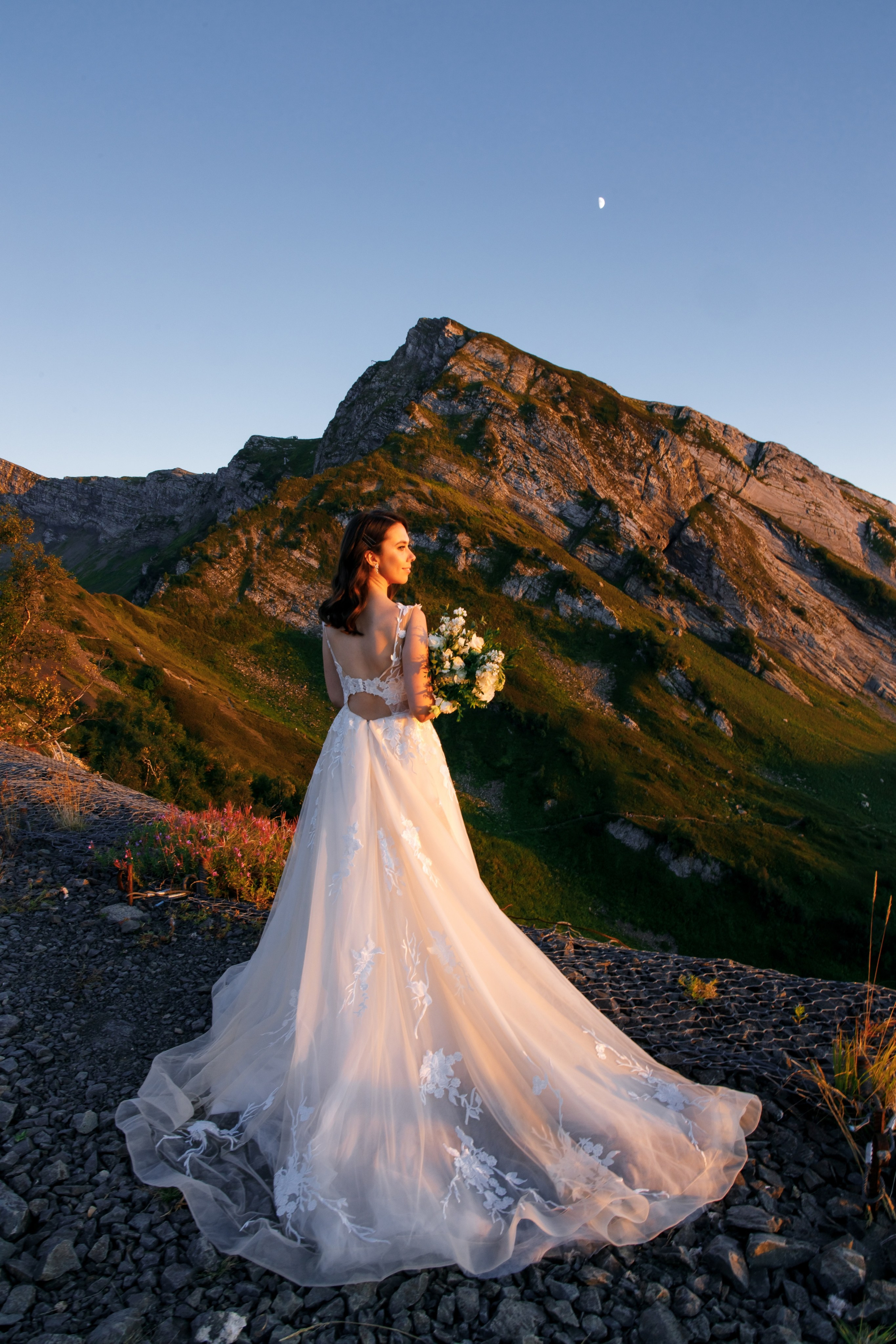 Невеста с букетом среди сосен в свадебной локации Поляны