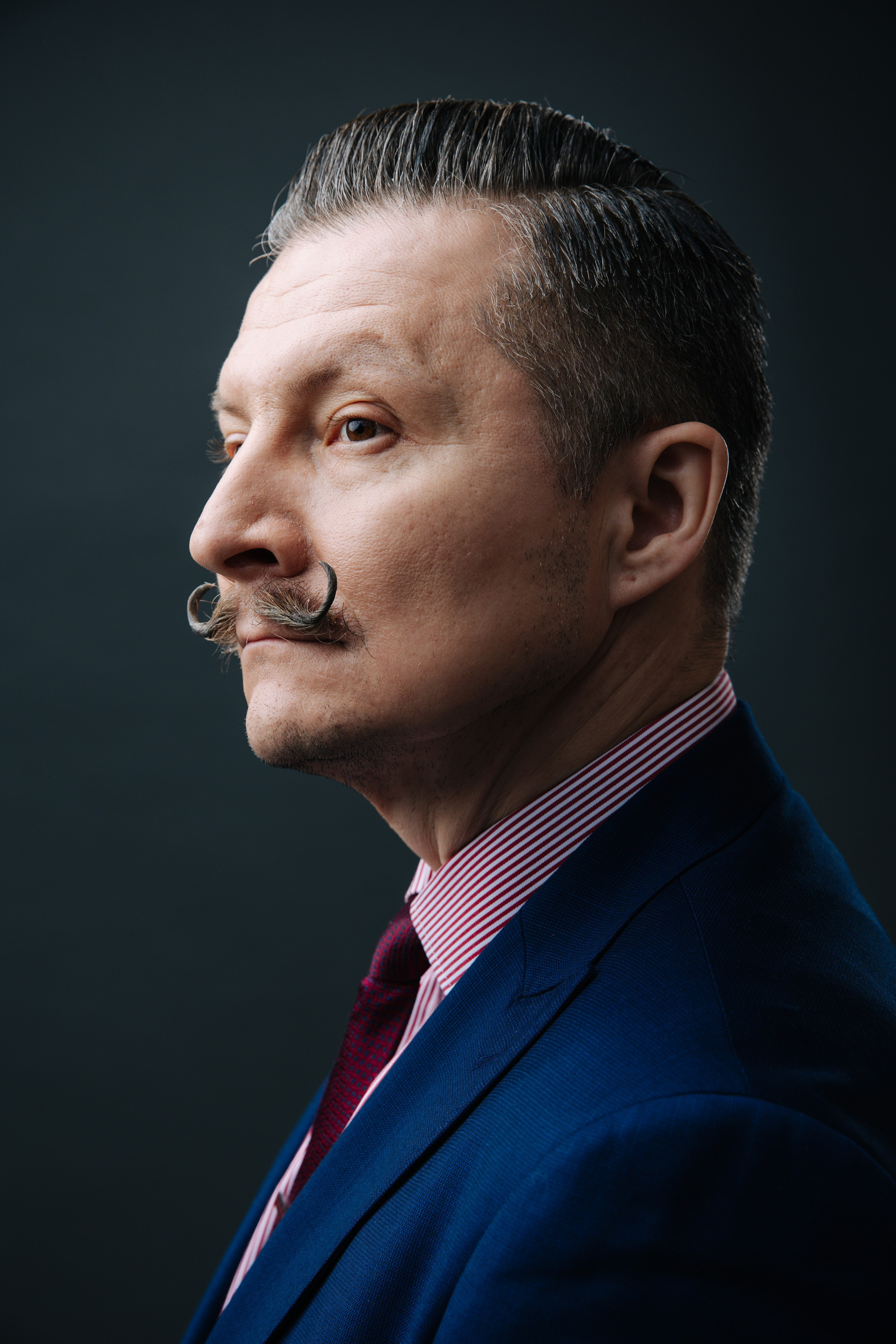 элегантный мужчина позирует для бизнес портрета на темном фоне