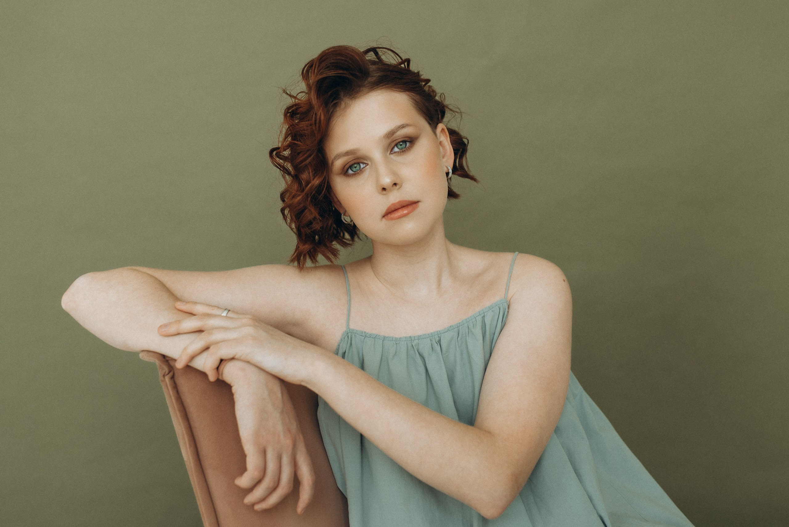 Стильный портрет девушки-подростка на стуле. Тёмная студия, сарафан, минималистичный образ. Фотосессия в подарок на 15 лет