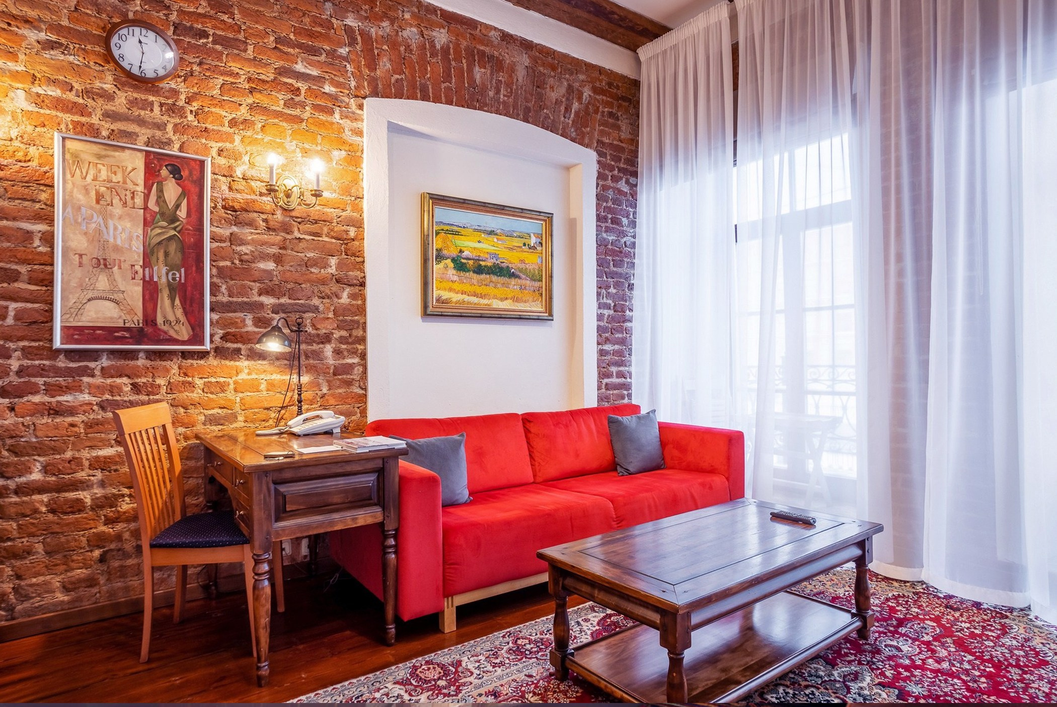 Интерьерная фотосъемка гостиной в контрастных цветах стера под кирпич красный яркий диван на полу ковер