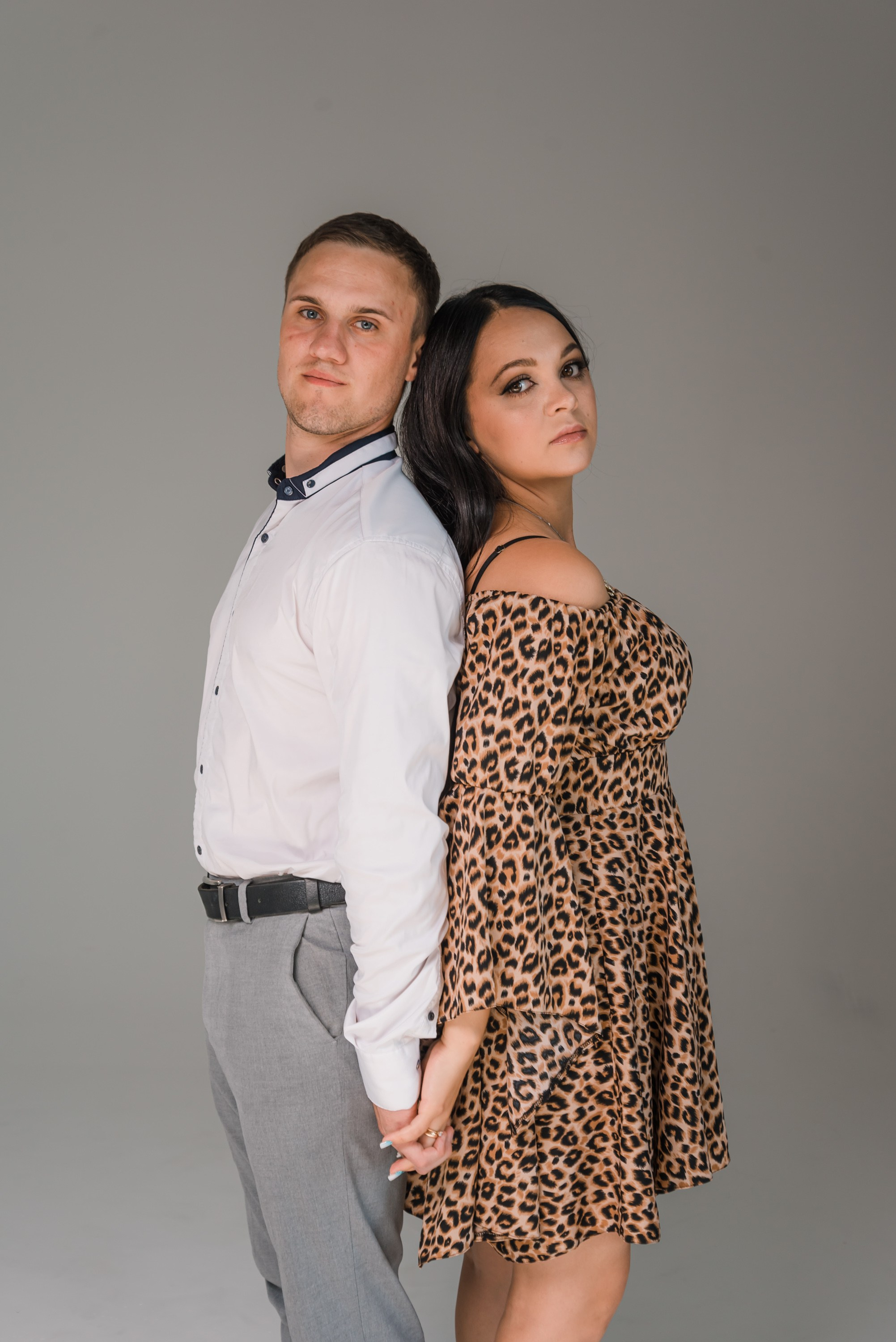 На фото муж и жена стоят спиной друг к другу.