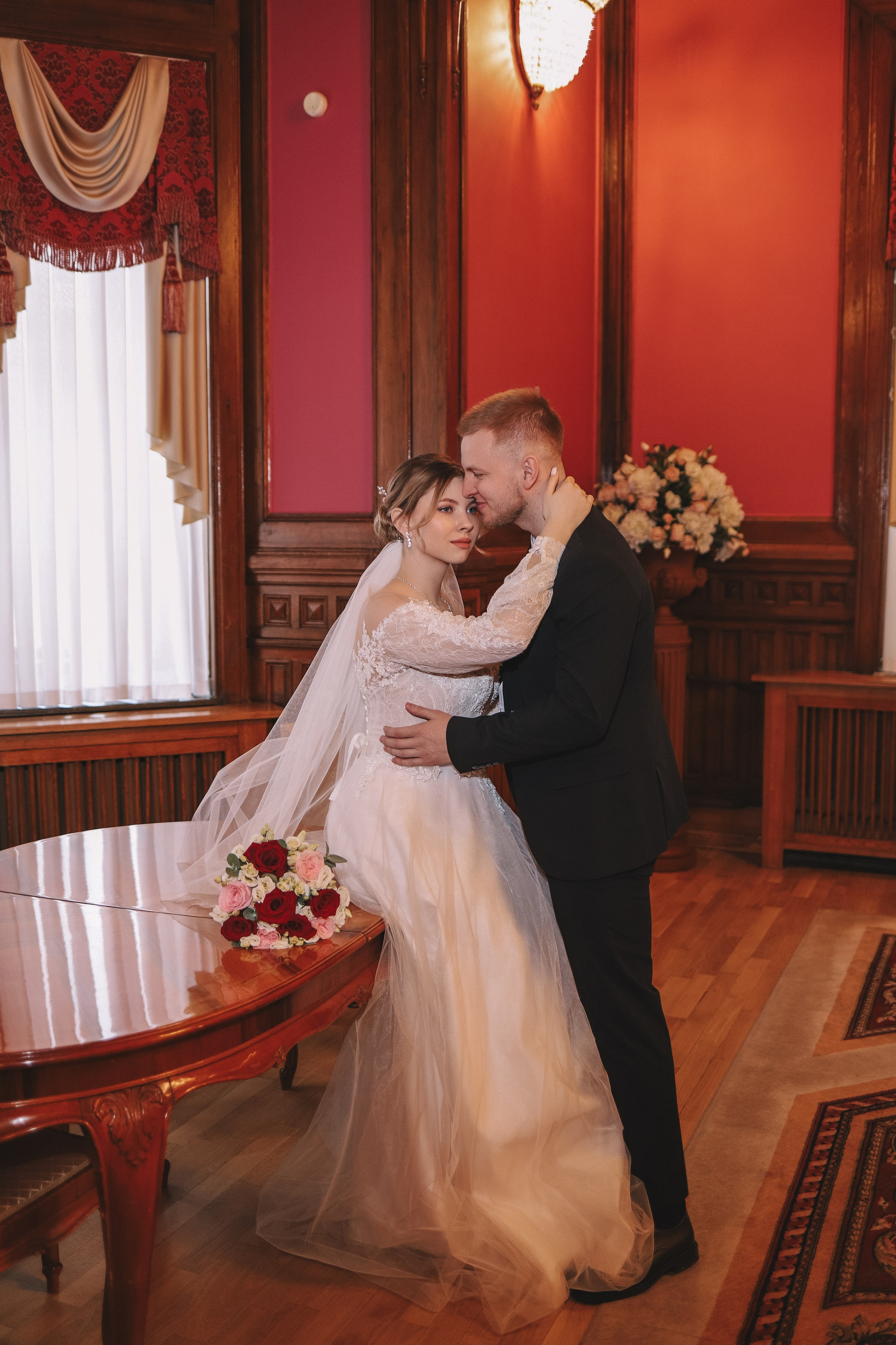 Жених и невеста стоят в зале ЗАГСа, вид со спины