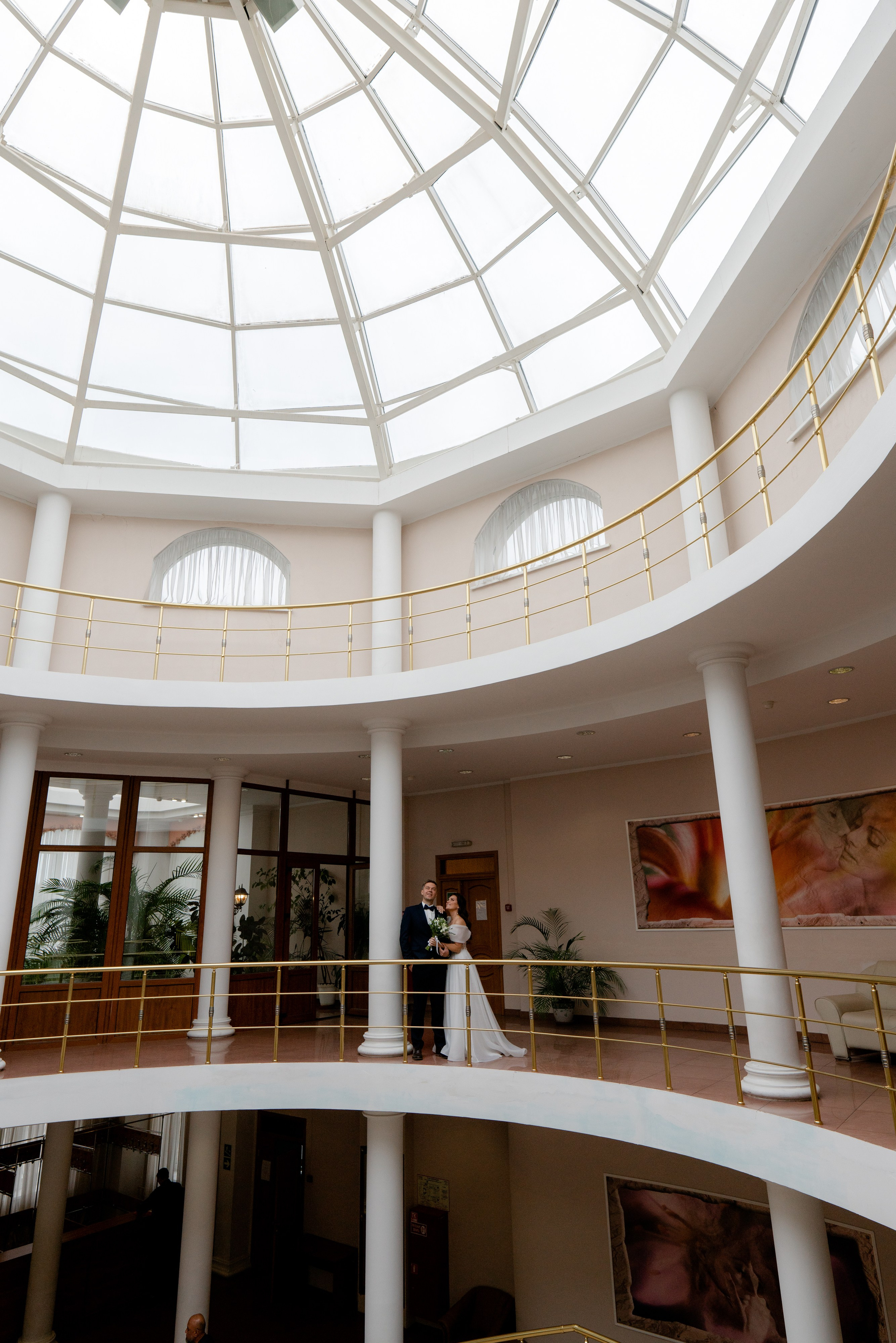 жених и невеста стоят вдалеке в загсе