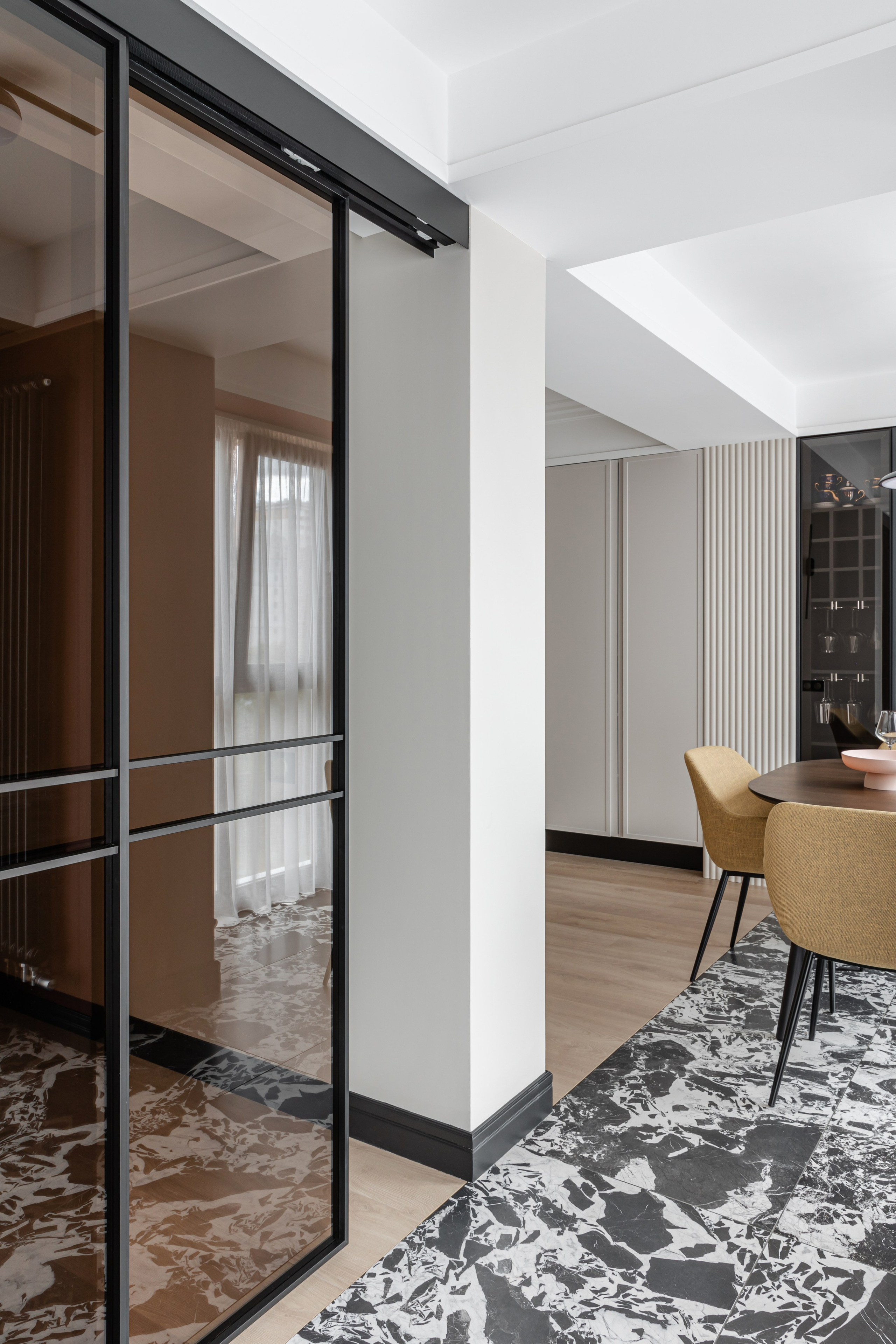 Зонирование стеклянной перегородкой спальни от гостиной.