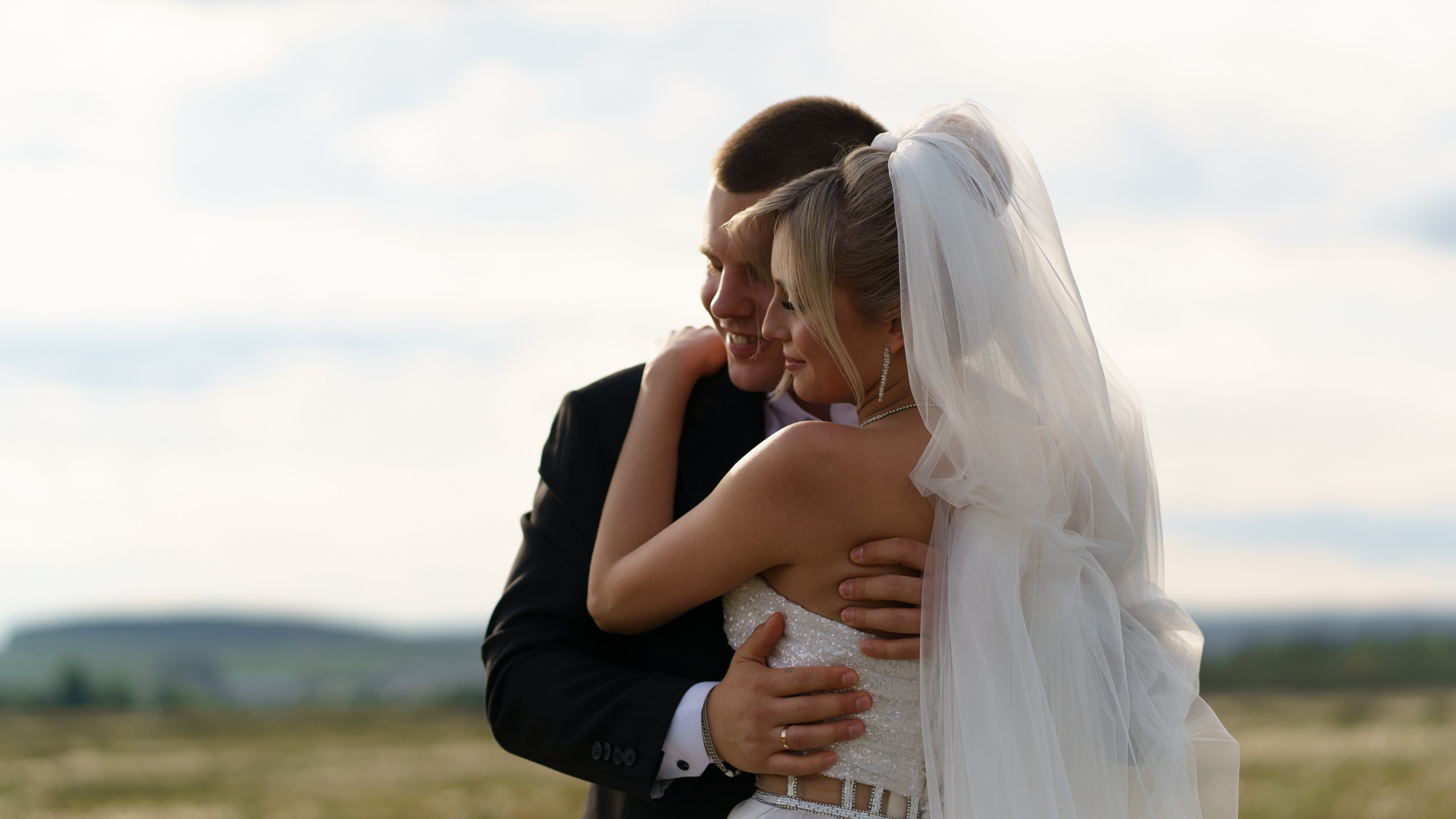 Танец двух сердец: невеста в воздушном платье доверчиво склоняет голову на плечо жениха, а ветер играет с её фатой | сочетание свадебной и портретной съемки Екатеринбург