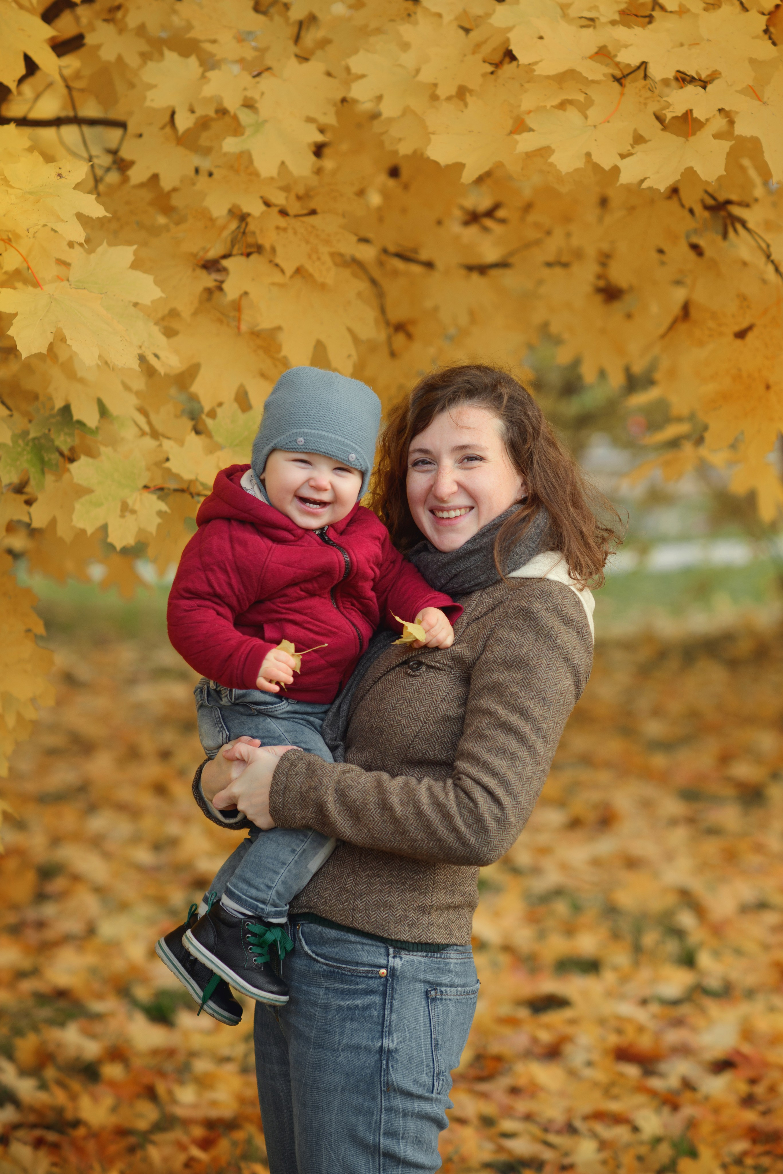 Photo shoot of a mom with baby in autumn. Photos with yellow leaves