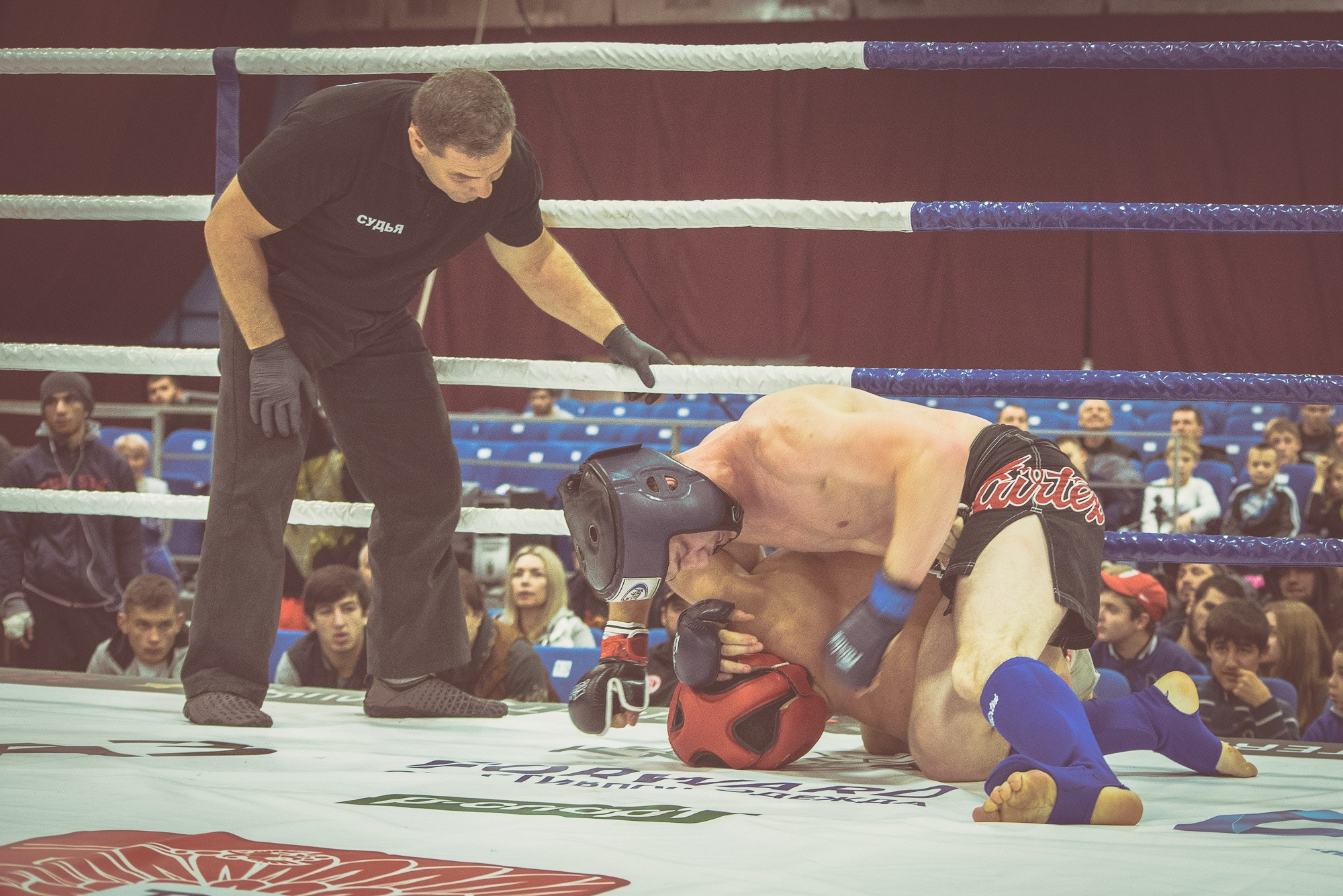 Судья в чёрной одежде следит за соблюдением правил боя