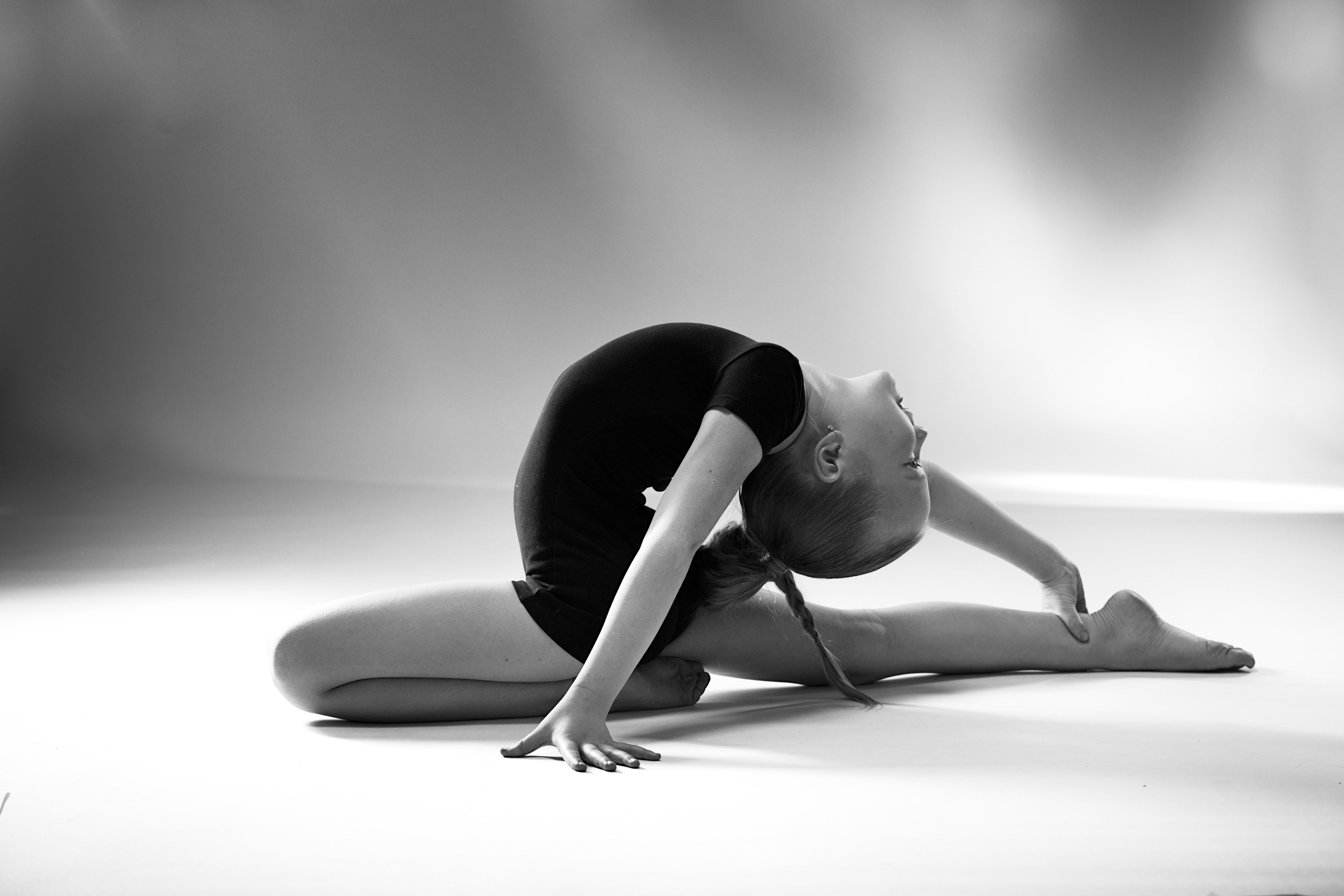 Эстетика художественной гимнастики: монохромный портрет девочки в черном купальнике, профессиональная студийная съемка