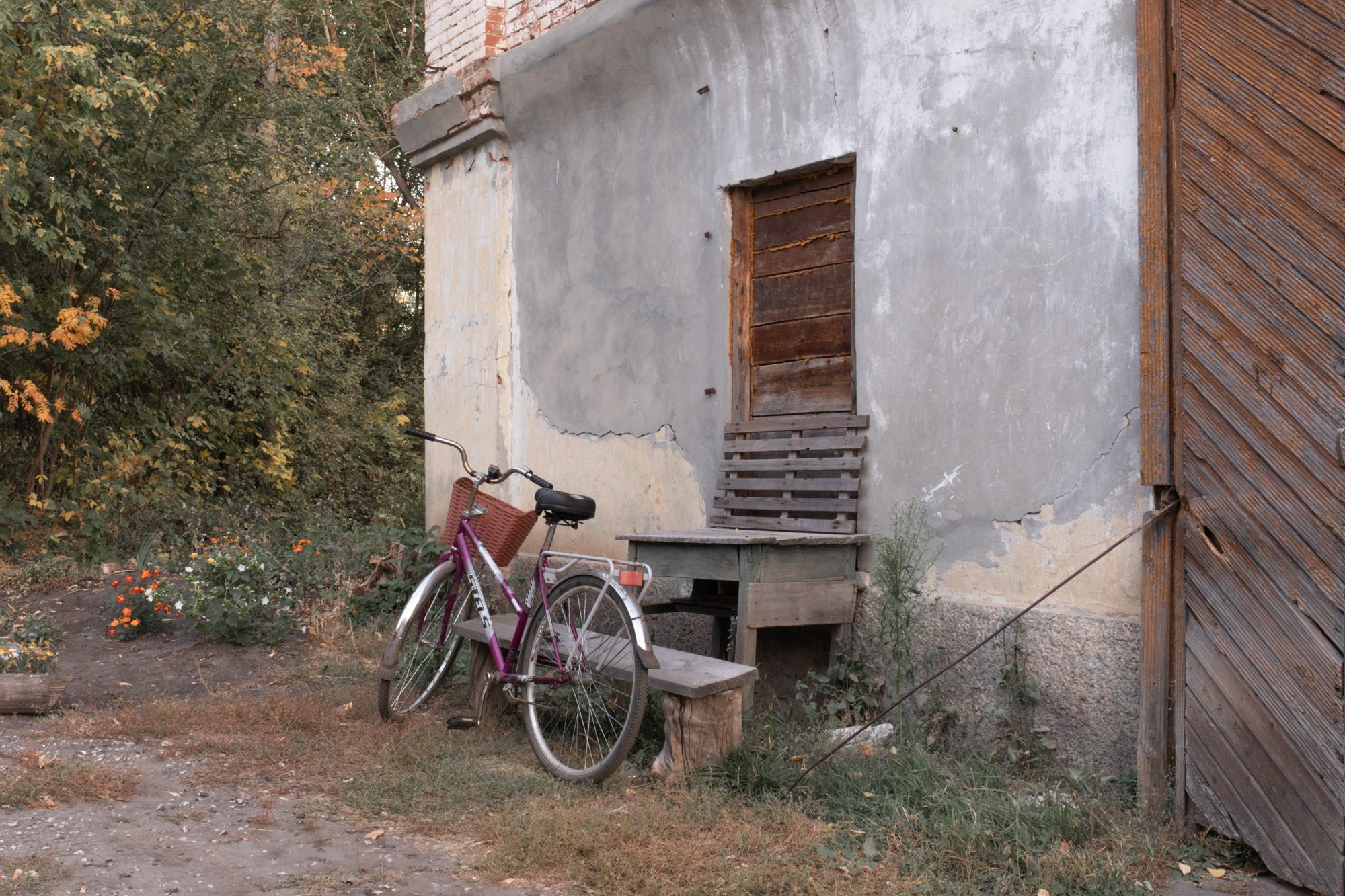 Велосипед пекаря у коммунарской хозяйственной постройки. Когда-то это здание служило интернатом для детей и складом. Сейчас лишь небольшая его часть используется для пекарни, остальные помещения заброшены.