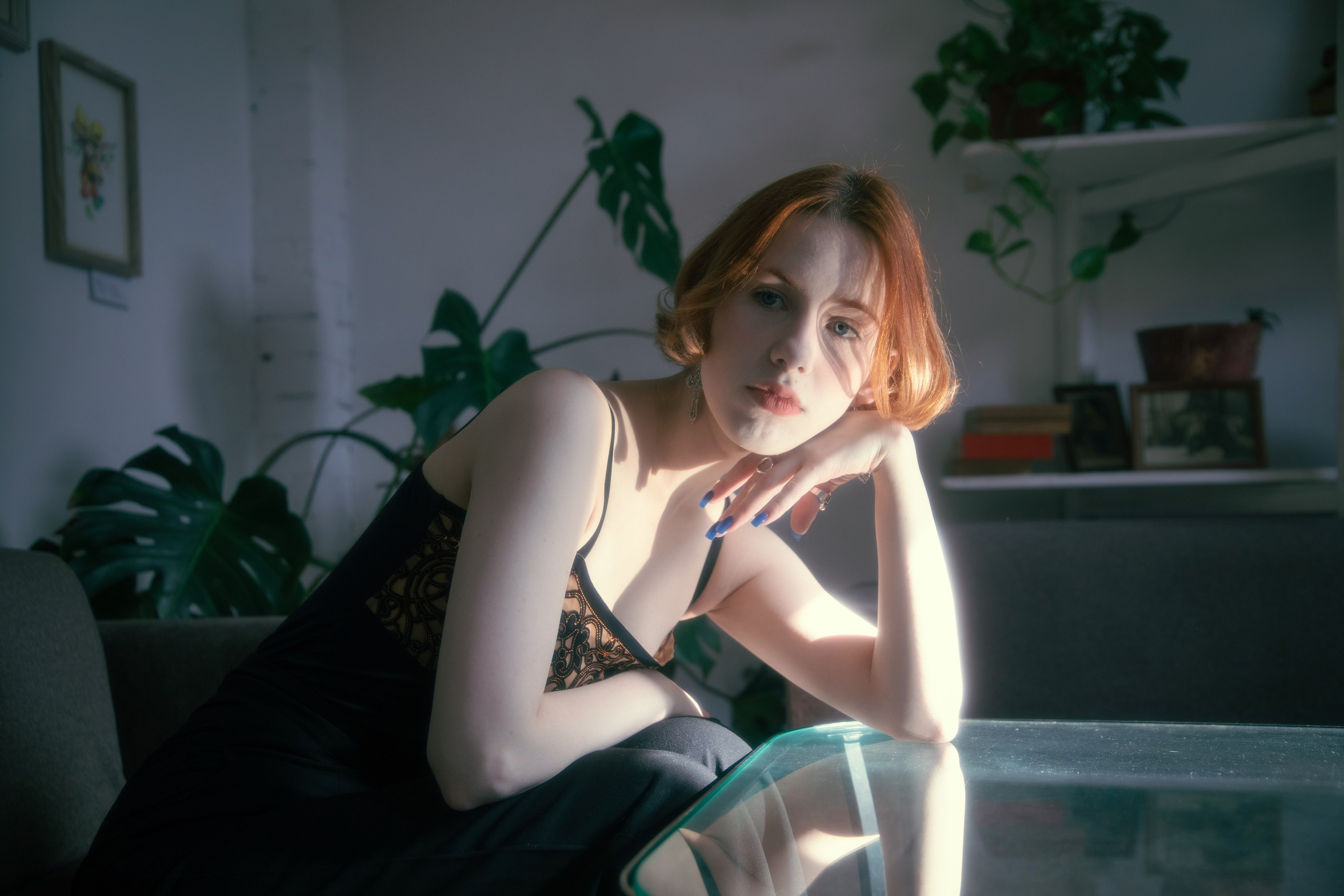 Портрет девушки с рыжими волосами в затененном интерьере