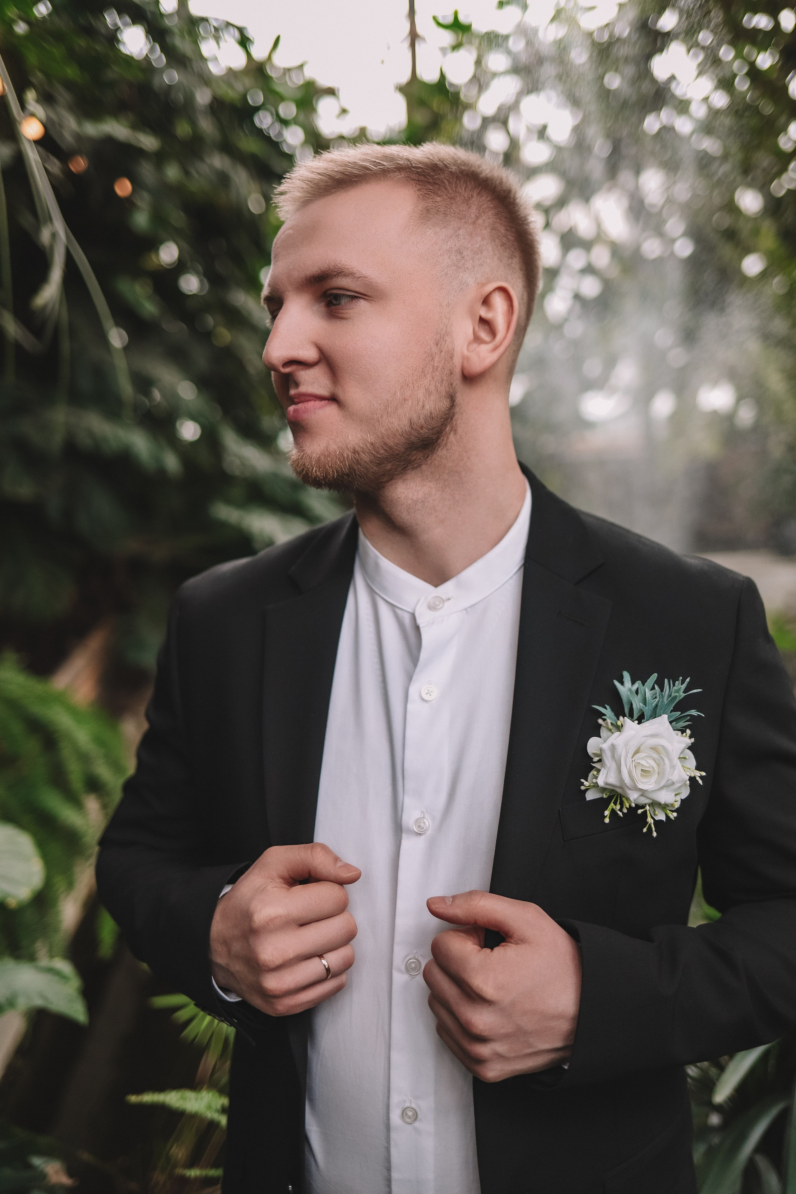 Портрет жениха в костюме с бутоньеркой, оранжерея