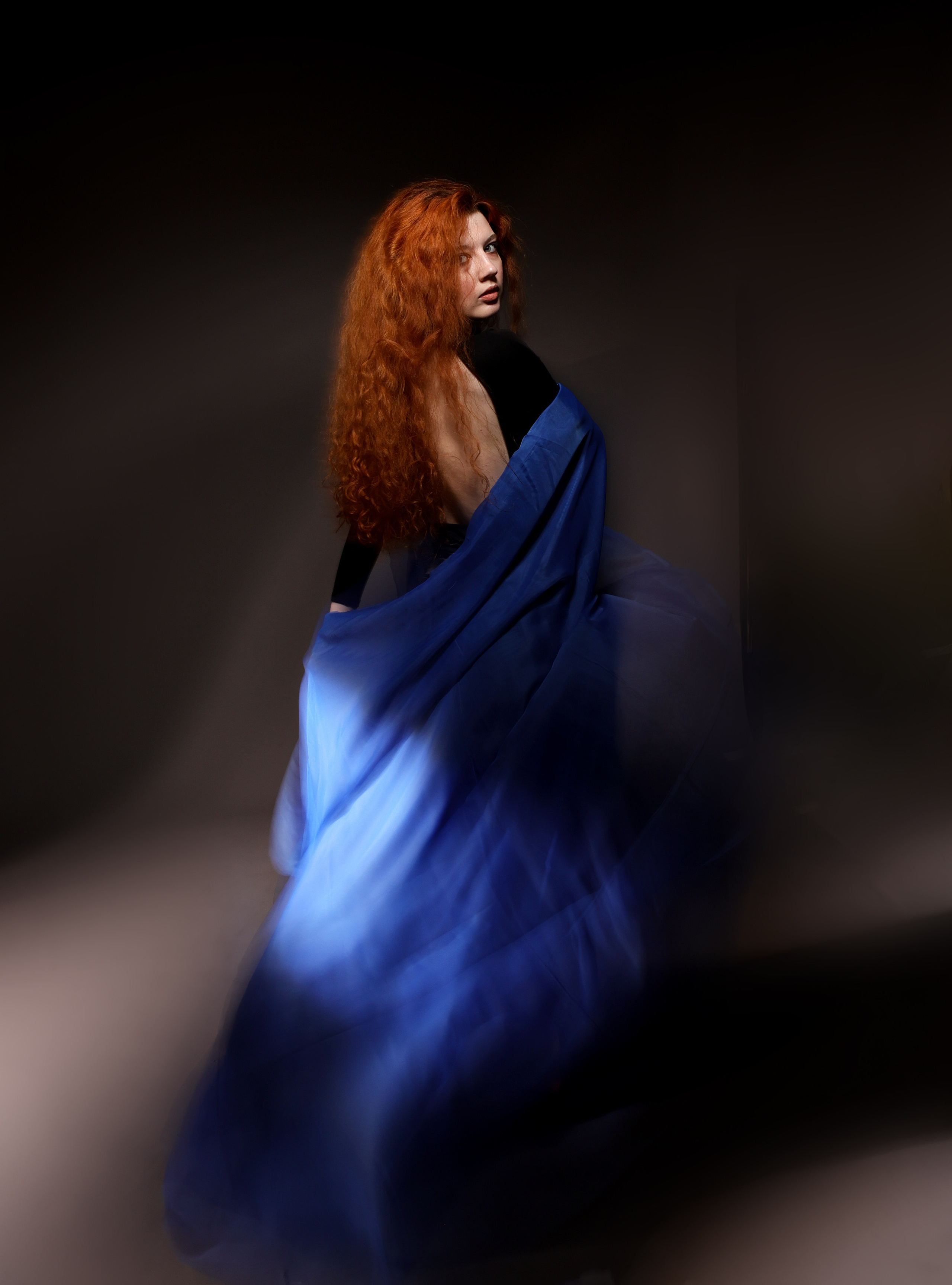 рыжеволосая девушка в синей накидке фото со смазом