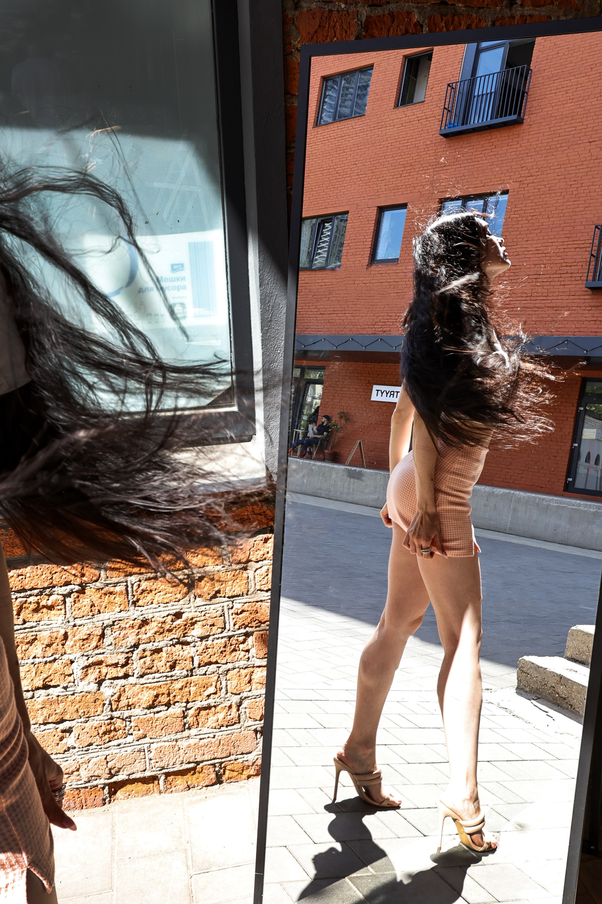 длинноногая девушка в короткой юбке отражается в зеркале