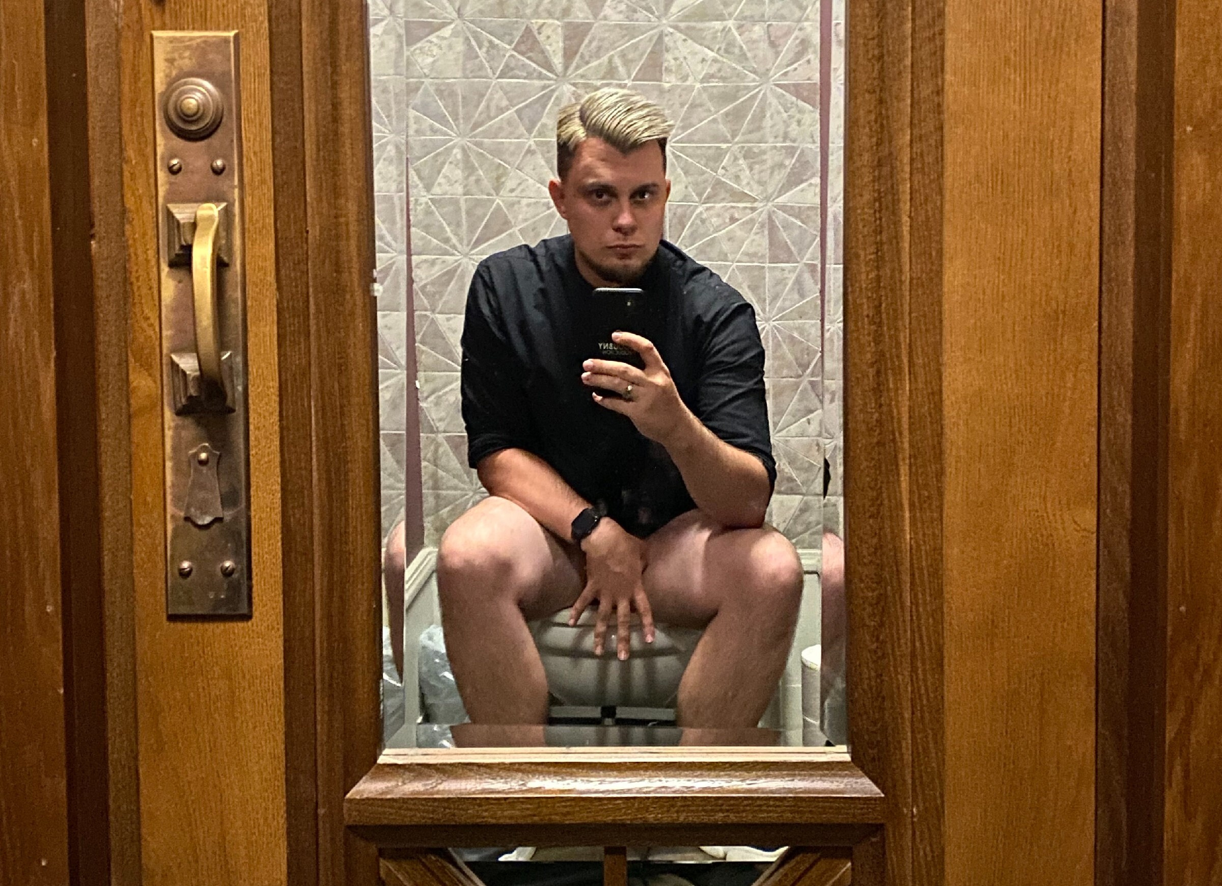 Парень в черной рубашке в туалетной комнате в замке БИП