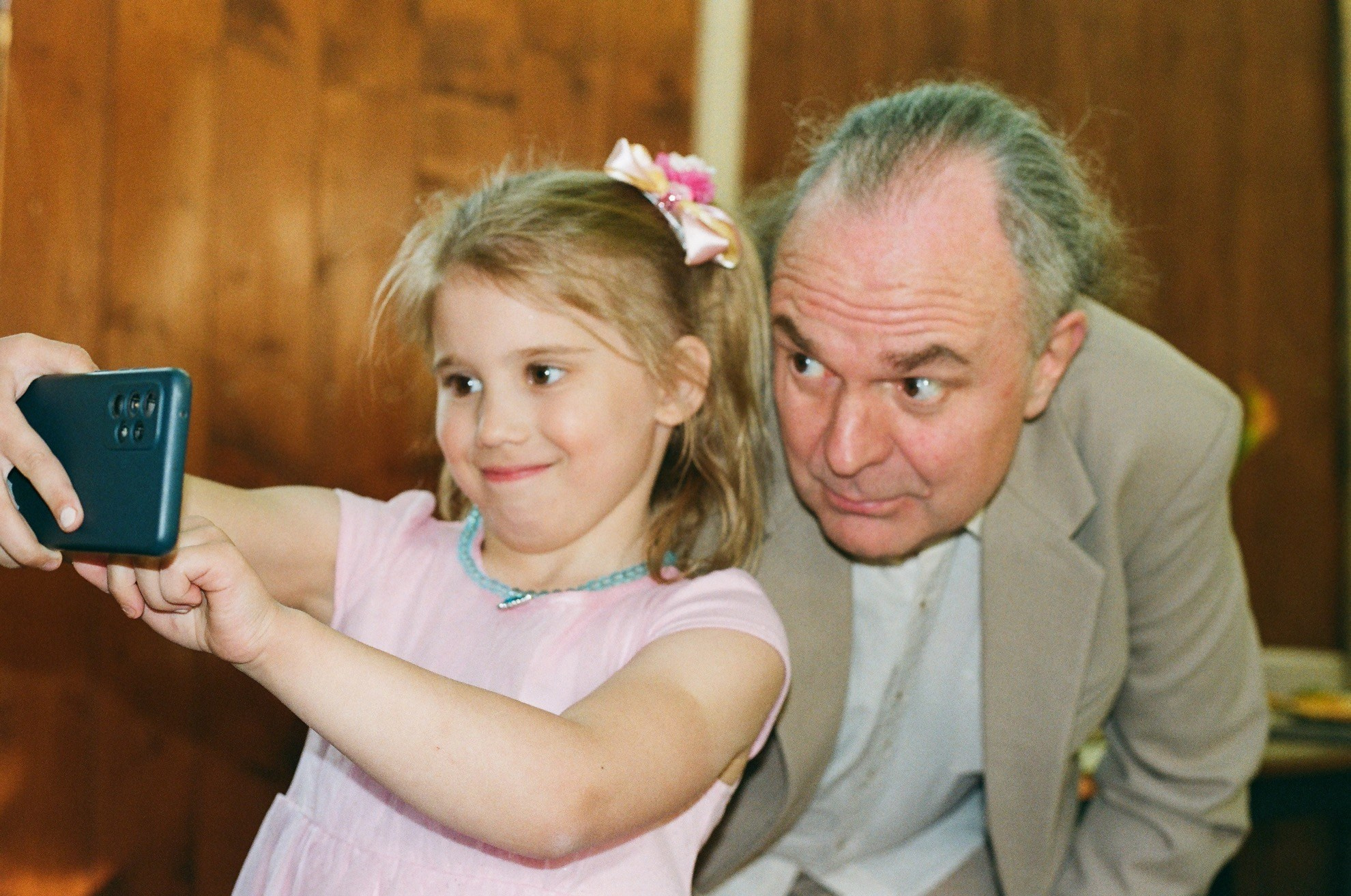 Девочка делает селфи с гостем, плёночный кадр с мягким светом