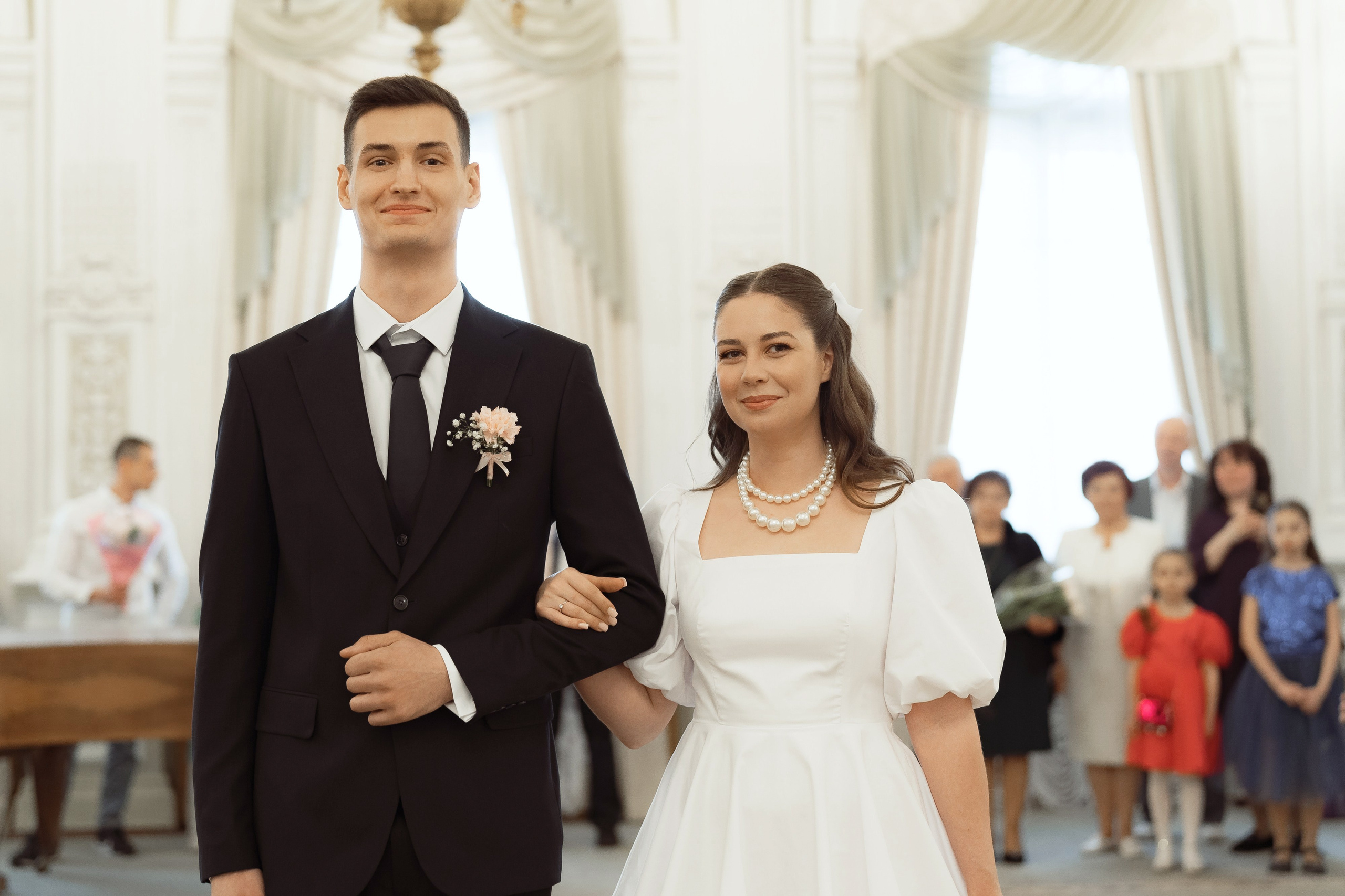 Жених и невеста слушают речь регистратора во время свадебной церемонии в ЗАГСе