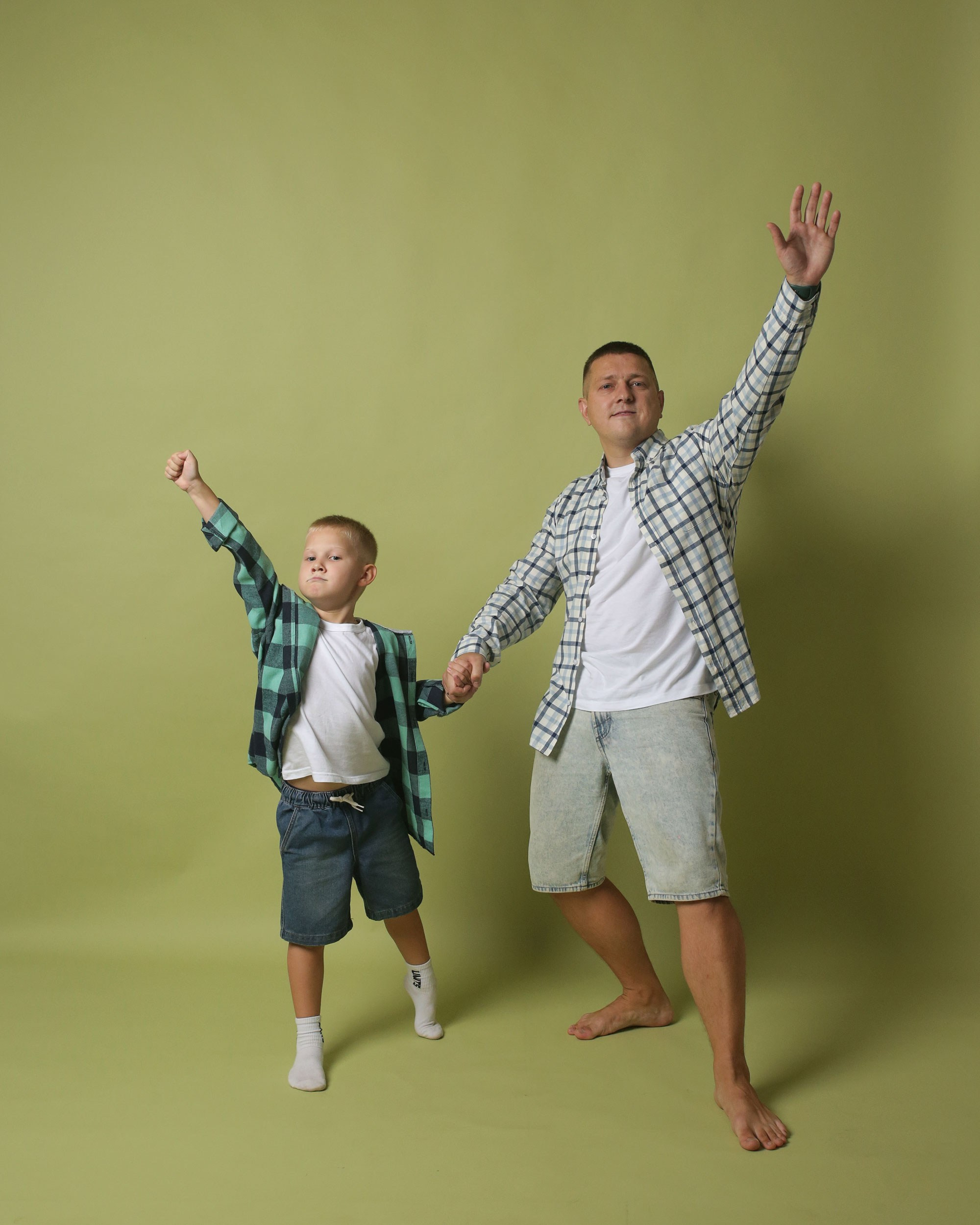 веселые отец и сын на зеленом фоне в фотостудии