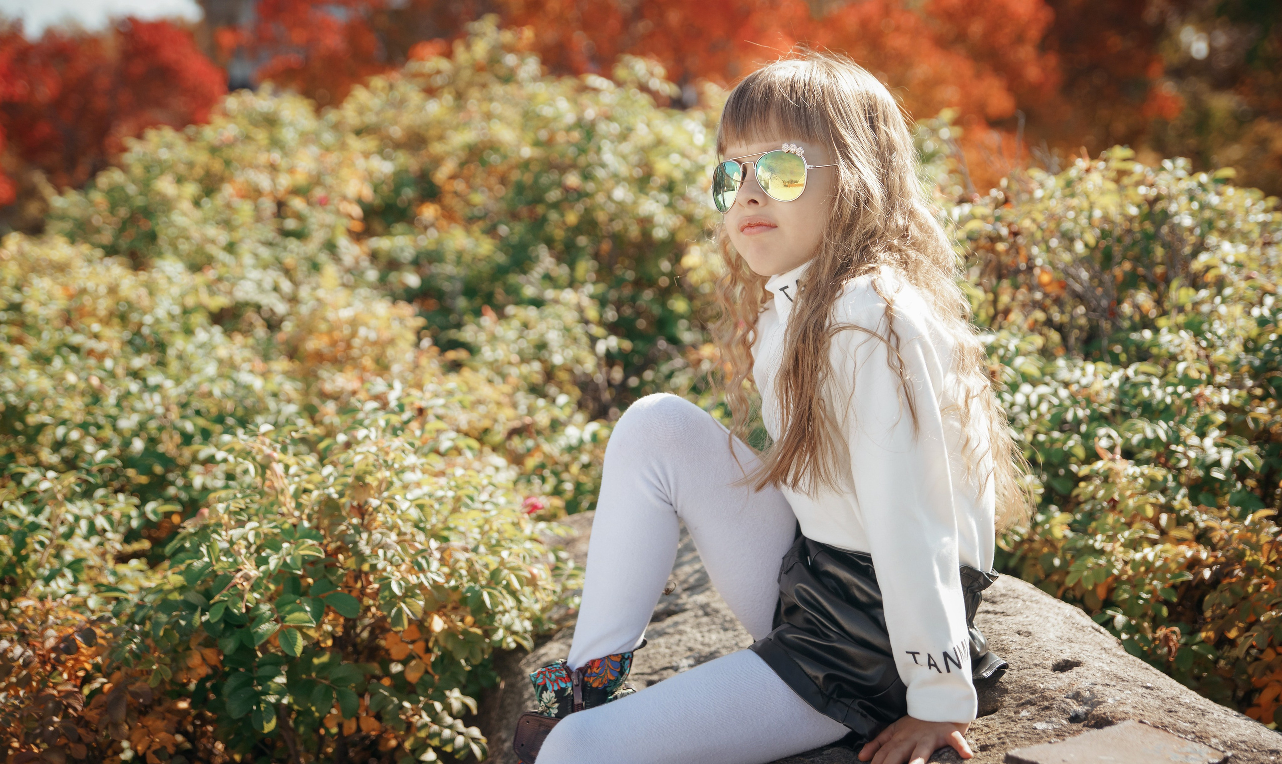 Семейная осенняя фотосессия в парке - девочка сидя на камне