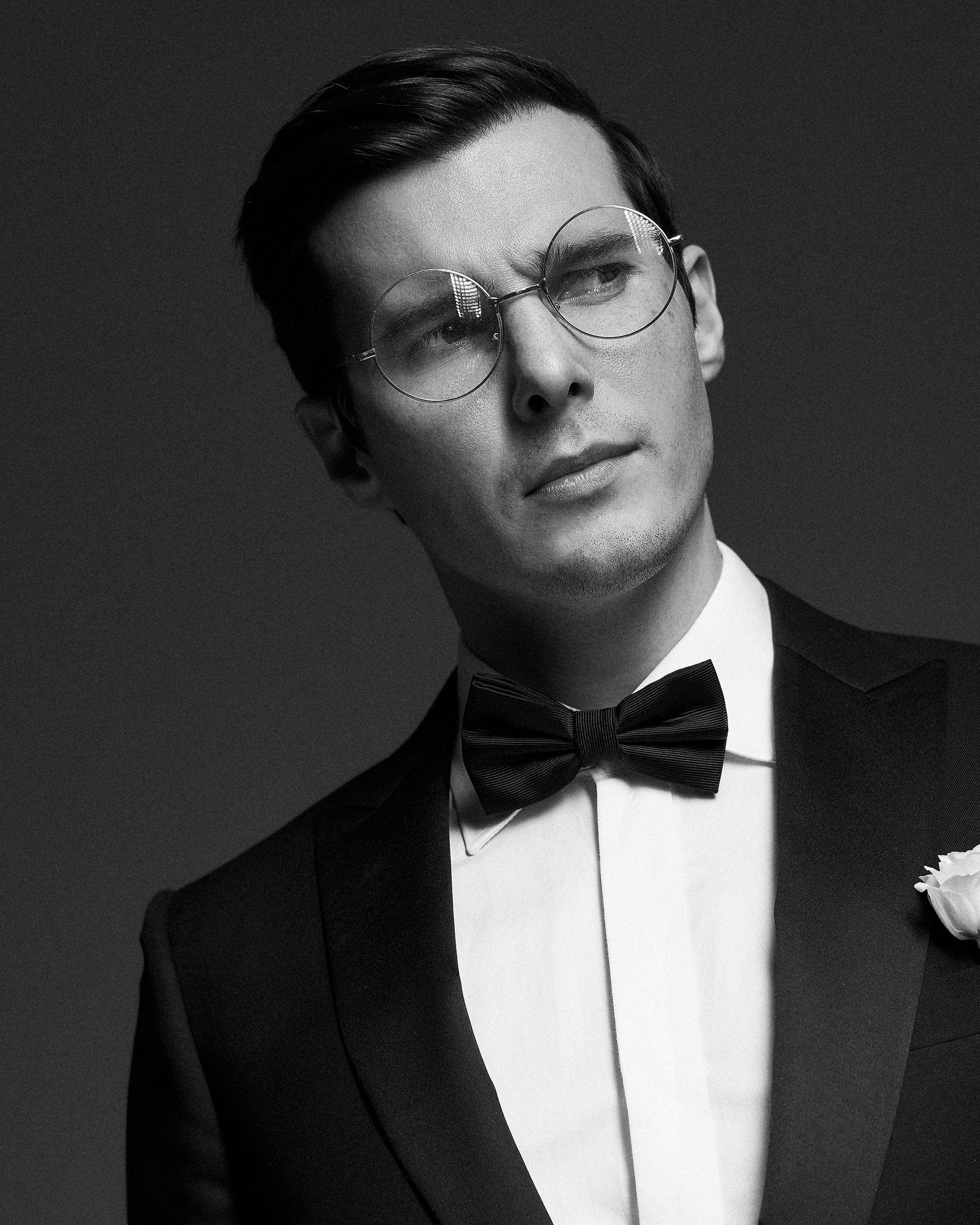 На свадебной съемке портрет жениха в смокинге на тёмном фоне. Спокойное выражение лица, внутренняя уверенность, никакой суеты. Фотограф Дмитрий Цветков, Санкт-Петербург