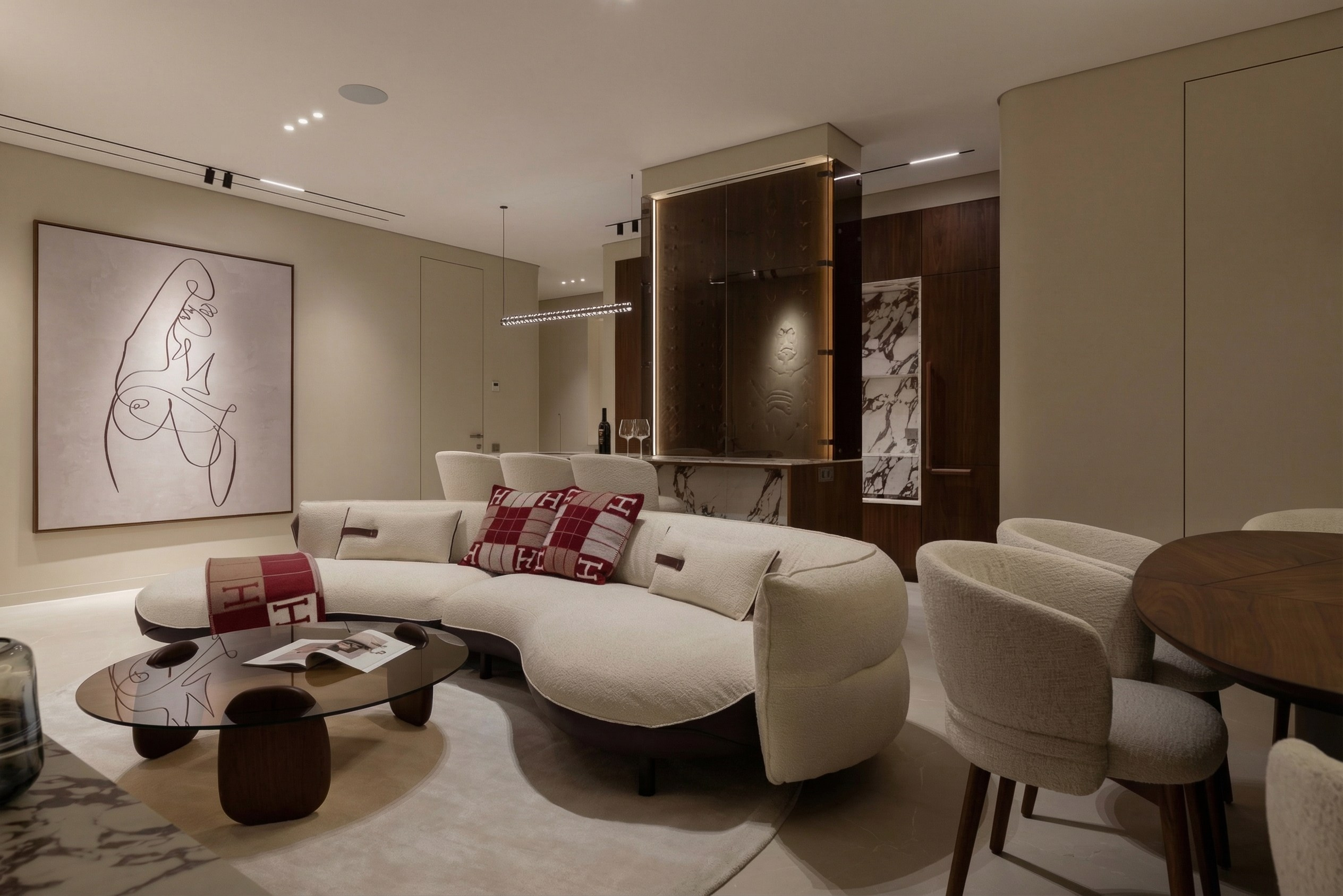 Интерьер гостиной в квартире 85 м² от Валерии Котович: радиусный диван, обеденная зона, винная витрина и скрытые двери в потолок.