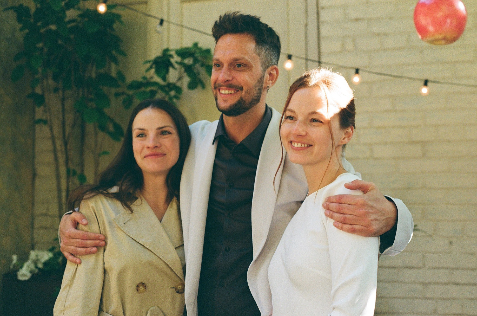 Мария, Евгений и подруга улыбаются в зале кафе, плёнка Gold 200 передаёт кремовые тона