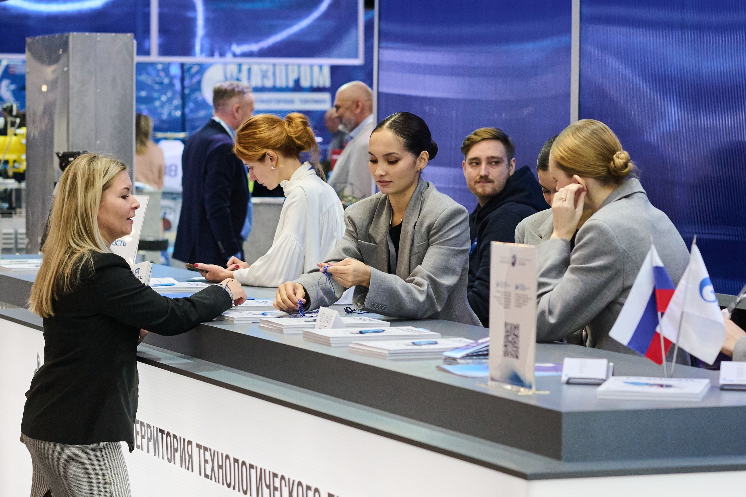 Сотрудницы за регистрационной стойкой на Петербургском международном газовом форуме 2025 в Экспофоруме