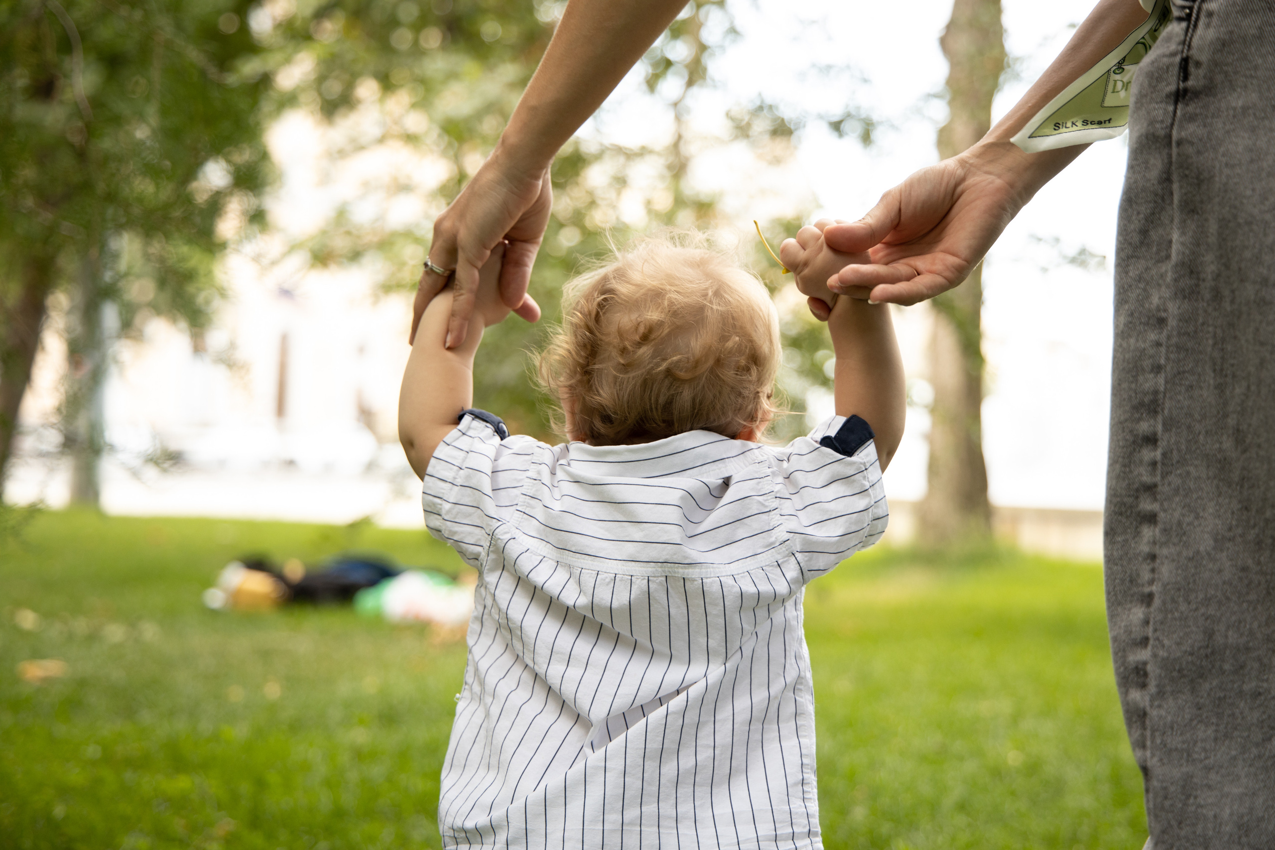 Малыш идет, держась за руки мамы, спиной к камере. Детская съёмка Астрахань.