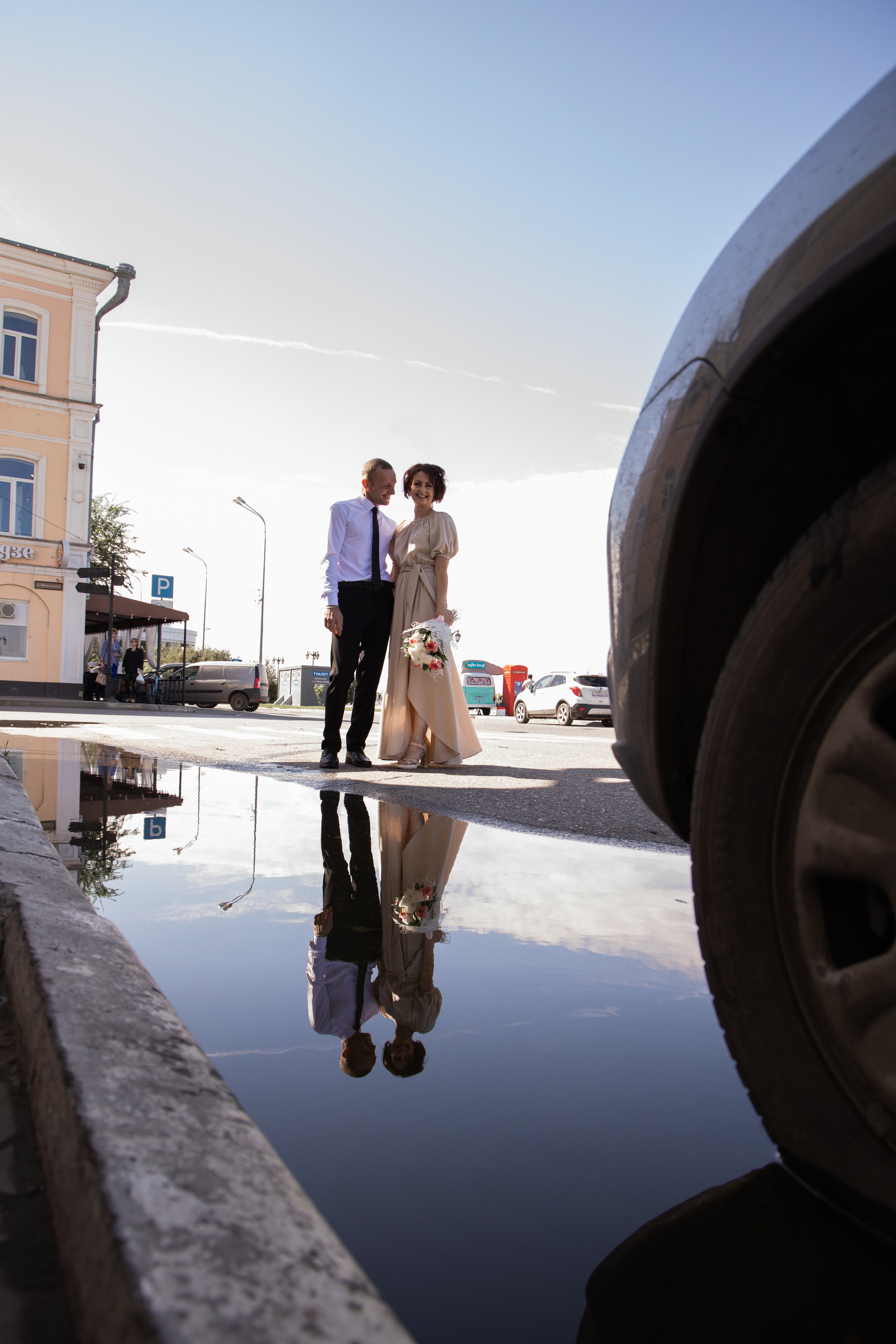 Молодожены в полный рост, на набережной. Их отражение в луже. Свадебная фотосессия Астрахань.