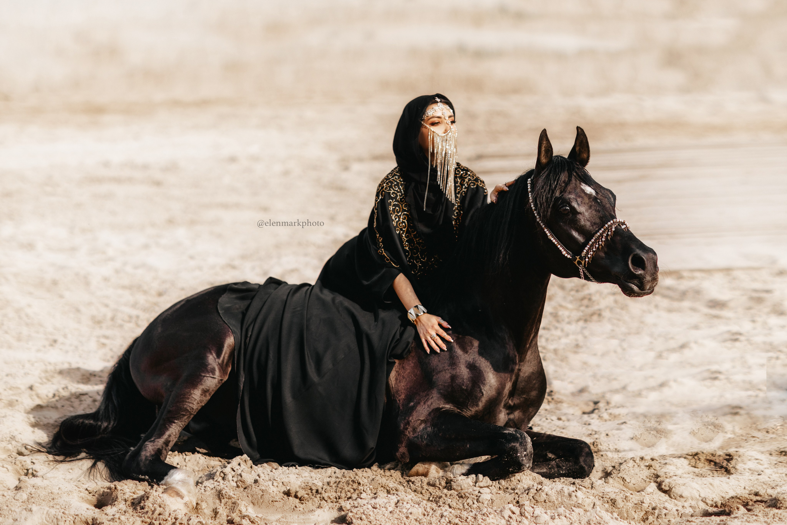 "Девушка в ярком восточном платье нежно сидит рядом с лежащей лошадью на мягкой траве. Спокойное выражение лица и расслабленная поза животного создают атмосферу умиротворения. Эта фотография идеально подходит для клиентов в Москве и области, желающих запечатлеть уникальные моменты с животными."