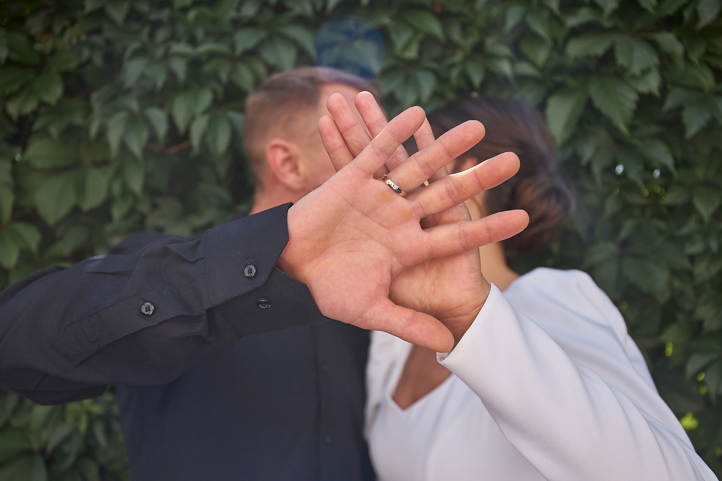 Свадебная пара целуются закрываясь рукой