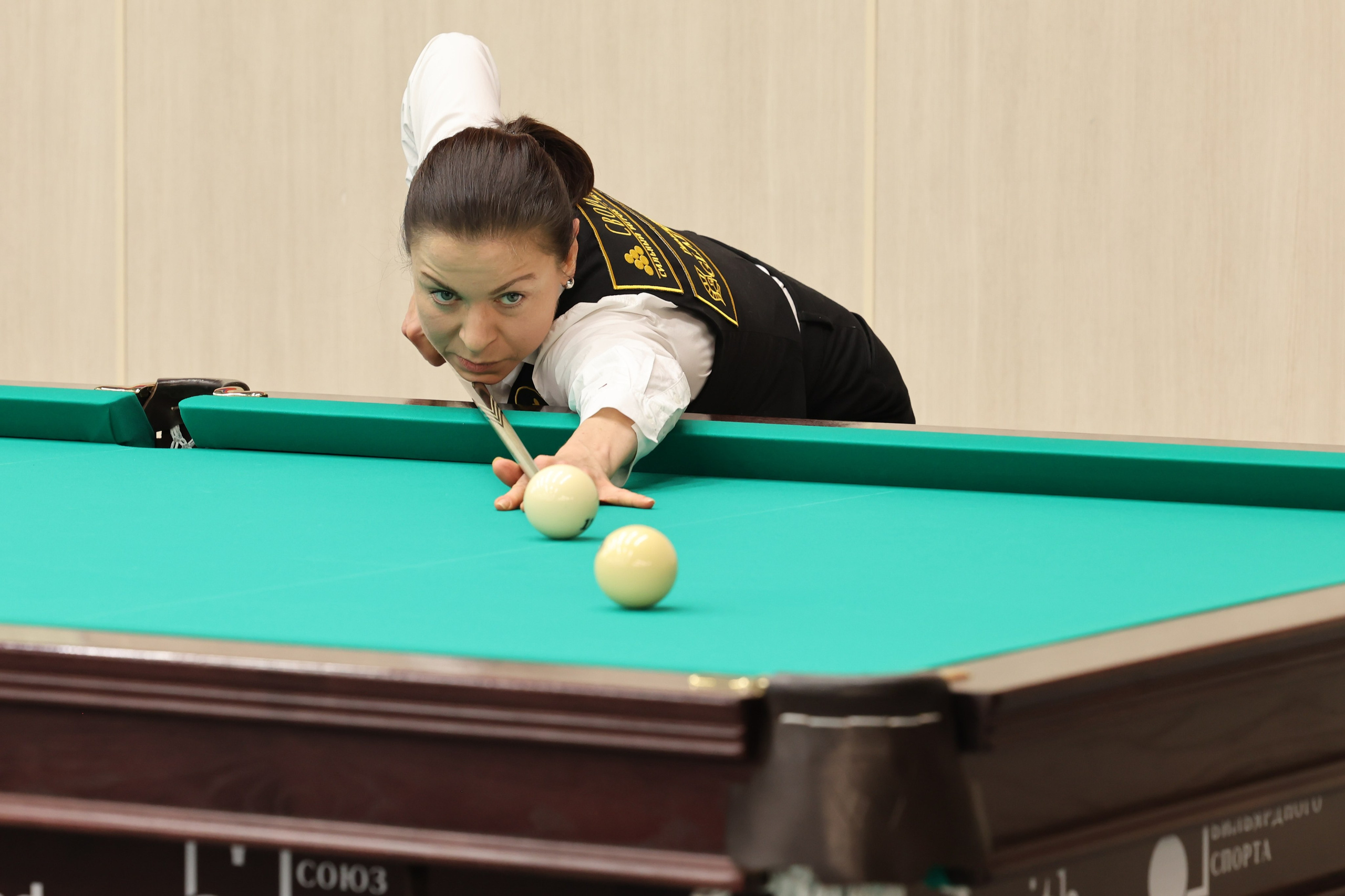 Красивая поза женщины готовящейся забить шар в лузу. Бильярдный чемпионат.