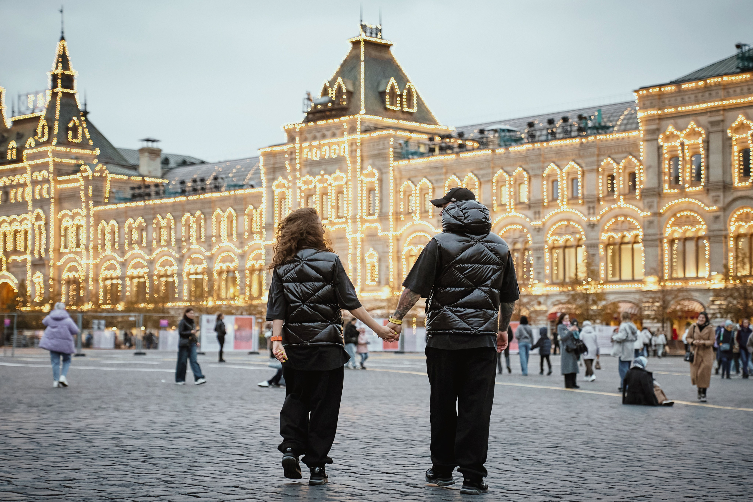 парочка влюблённых идет в ГУМ кадр с фотосессии на красной площади
