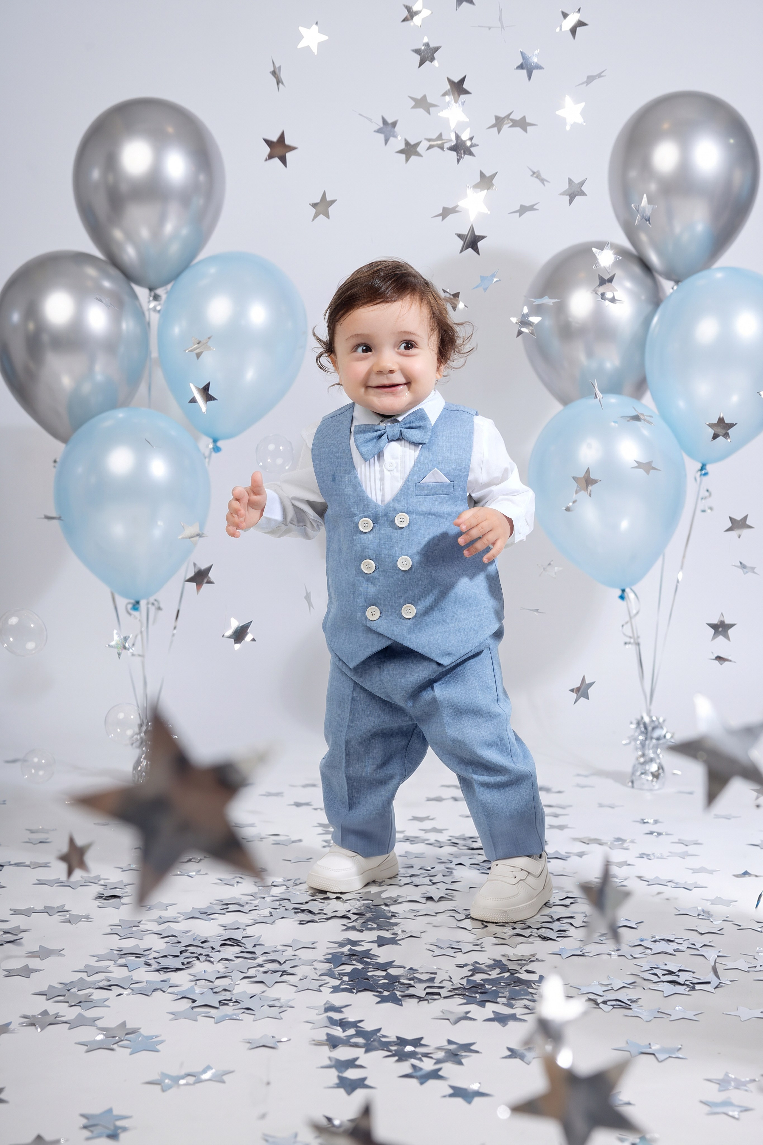 Студийный портрет годовалого мальчика в голубом костюме с воздушными шарами