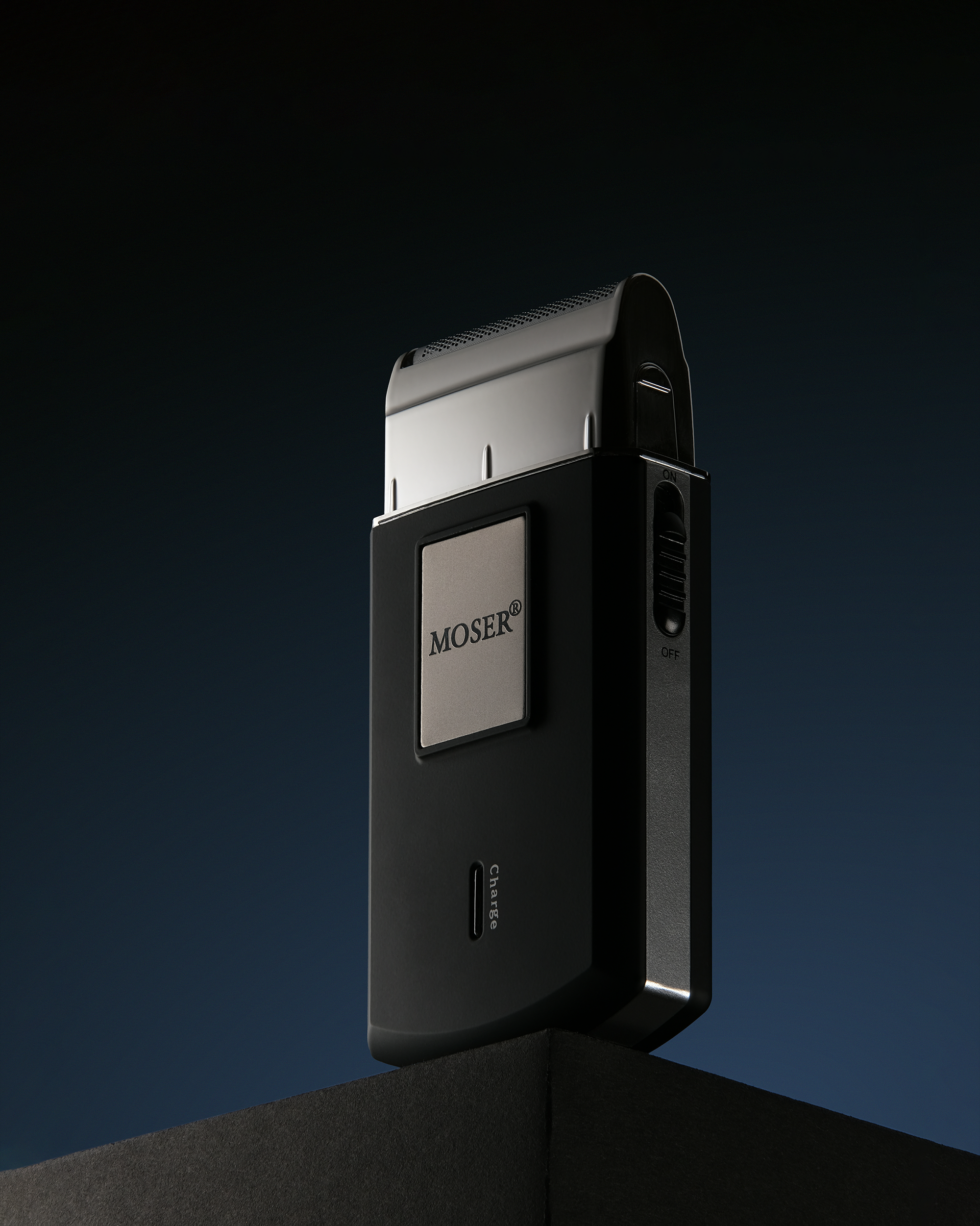 Профессиональная предметная съемка электробритвы MOSER для каталога и интернет-магазина | Рекламная фотография устройств для бритья и ухода на темном фоне, с акцентом на эффектные блики на металлических поверхностях и точную передачу тексту материала.