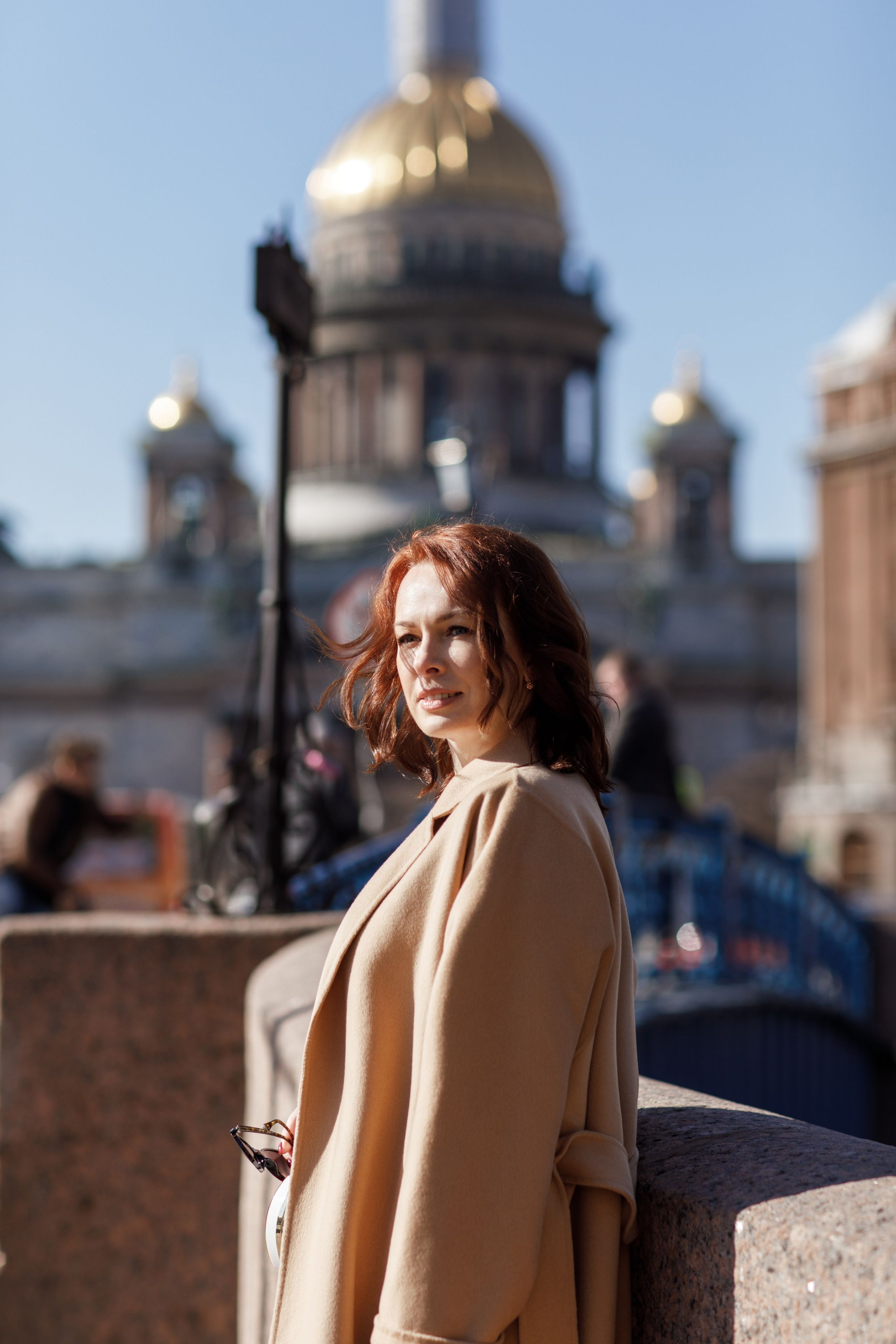 Рыжая девушка в бежевом пальто на фоне Исаакиевского собора
