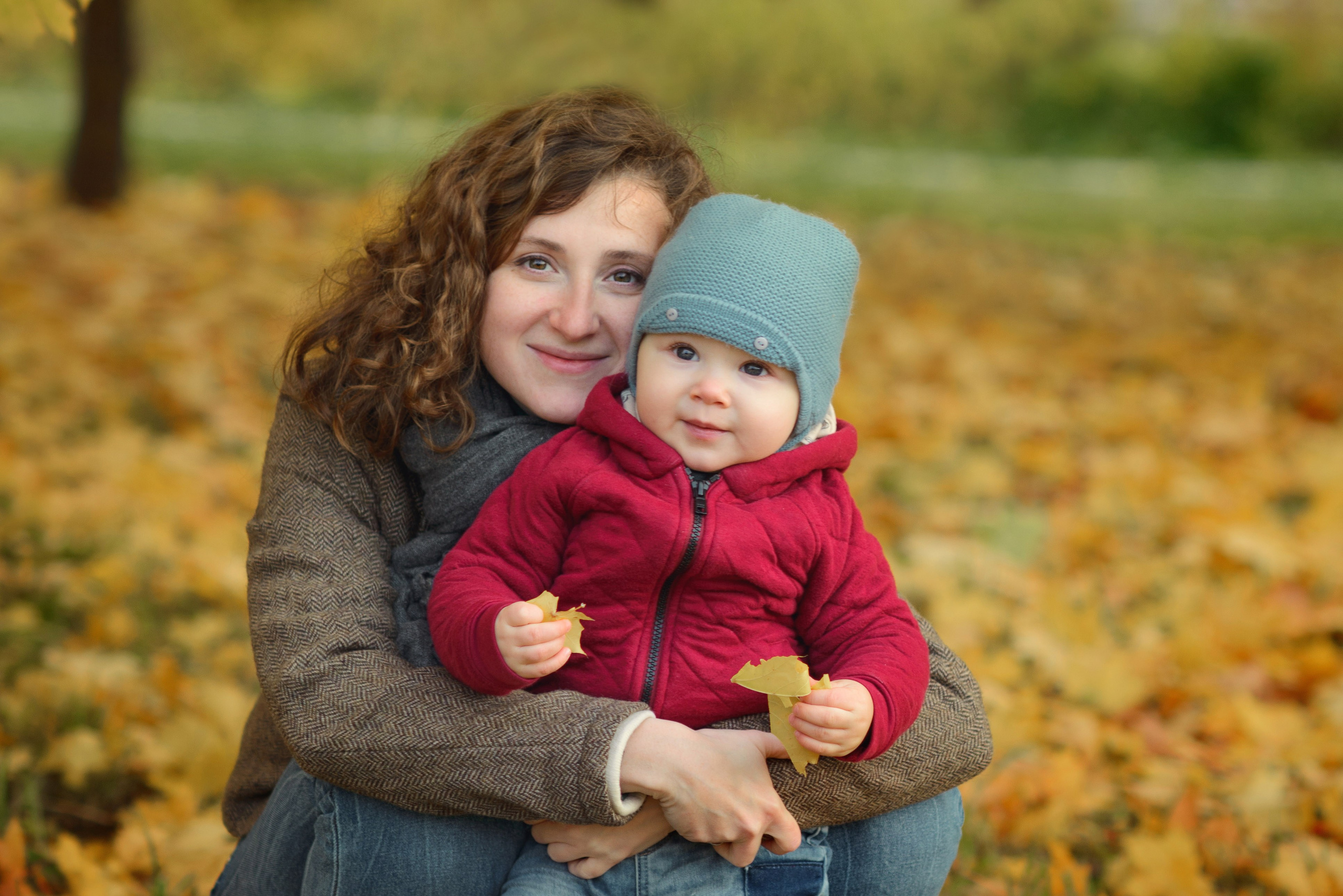 Photo shoot of a mom with baby in autumn. Photos with yellow leaves