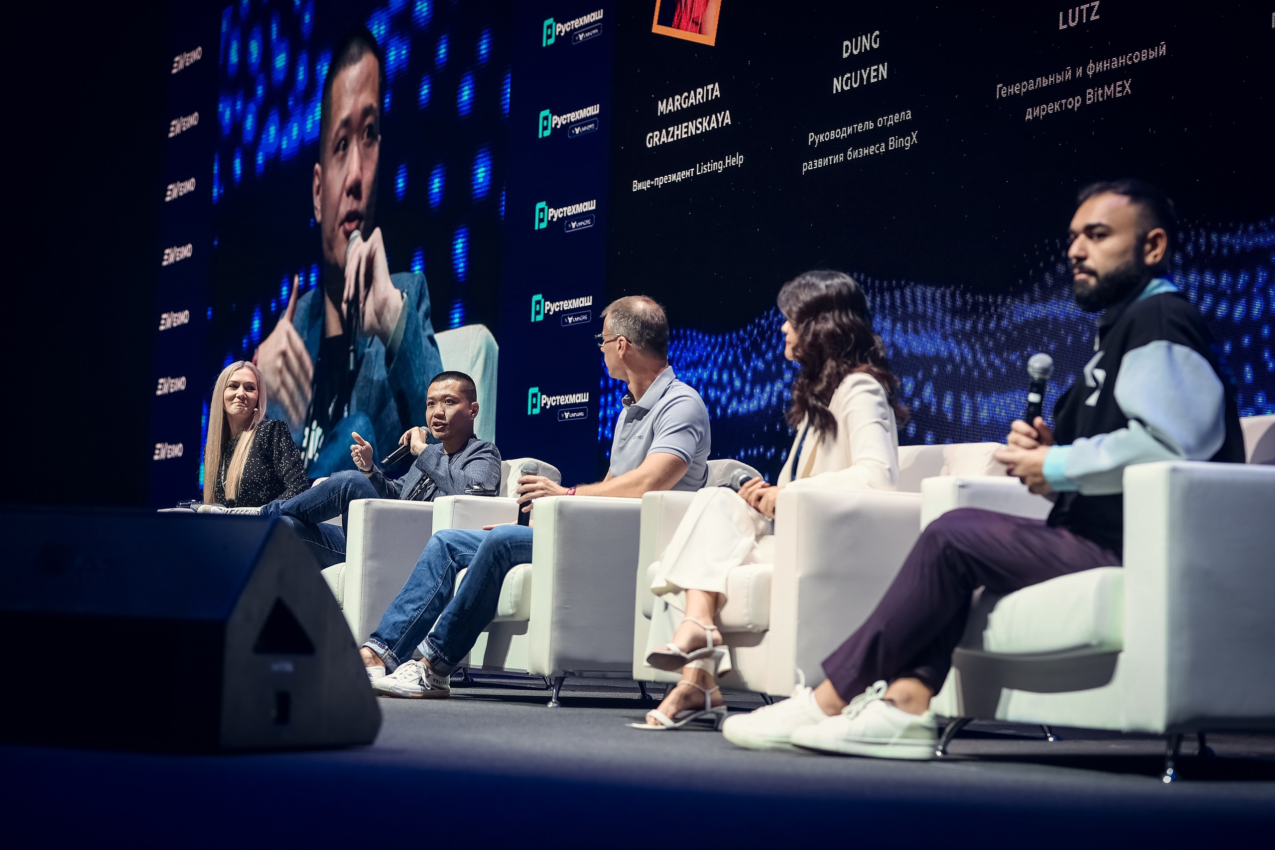 Панель из пяти спикеров на Blockchain 2025 в MTS Hall, включая выступающего представителя BINGX. Общий план сцены и атмосфера криптосаммита в Москве.