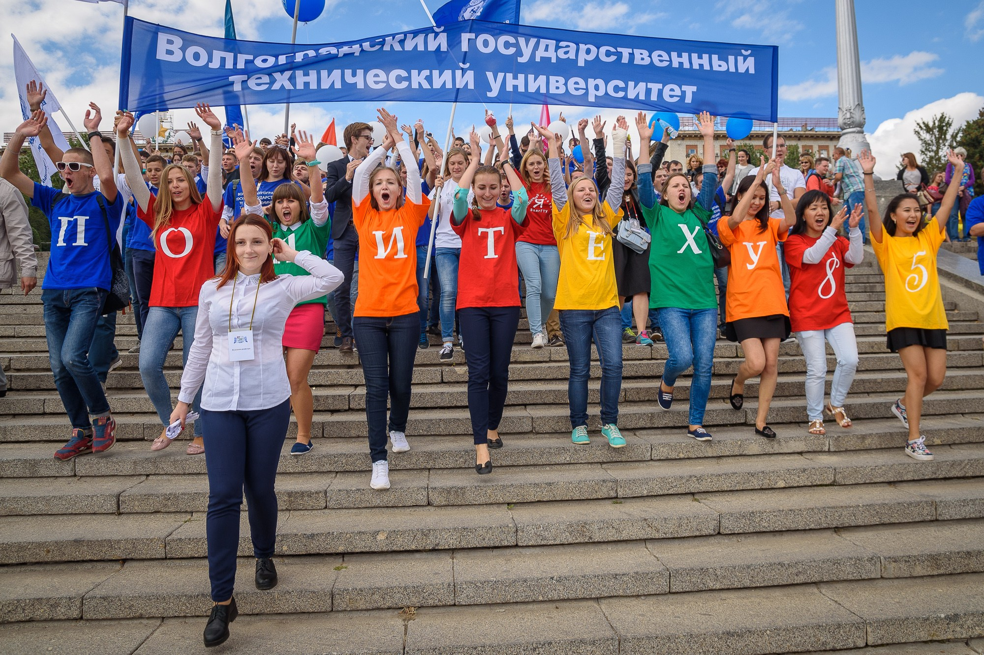 Студенты идут с транспарантом по ступеням набережной Волгограда