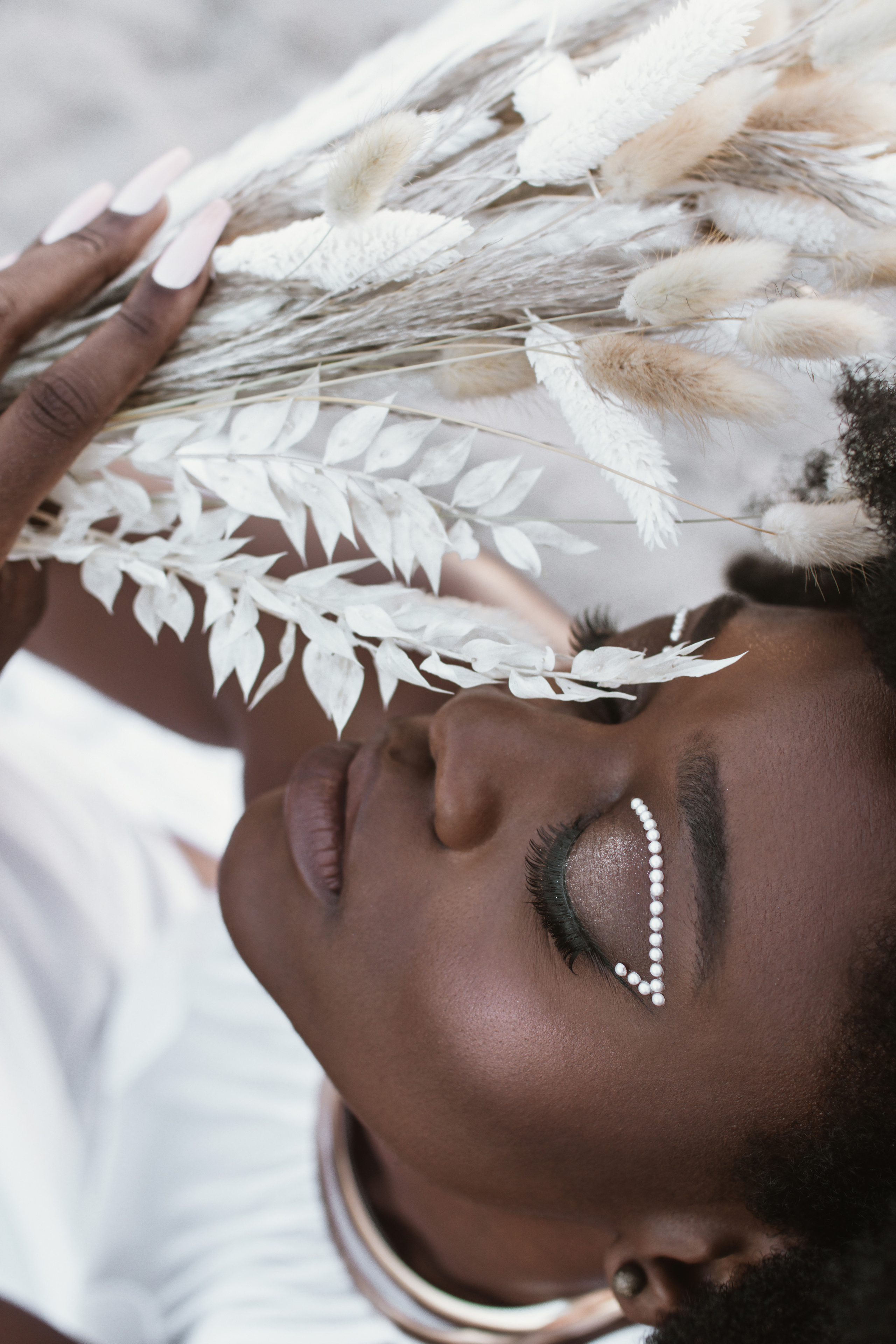 Close-up portrait of a woman with a boho bouquet of white flowers. Beautiful makeup with pearls on the eyes Professional photographer in Delray Beach, Boynton Beach, Boca Raton, Palm Beach, South Florida. women’s portraits, events, content, family and children’s shoots