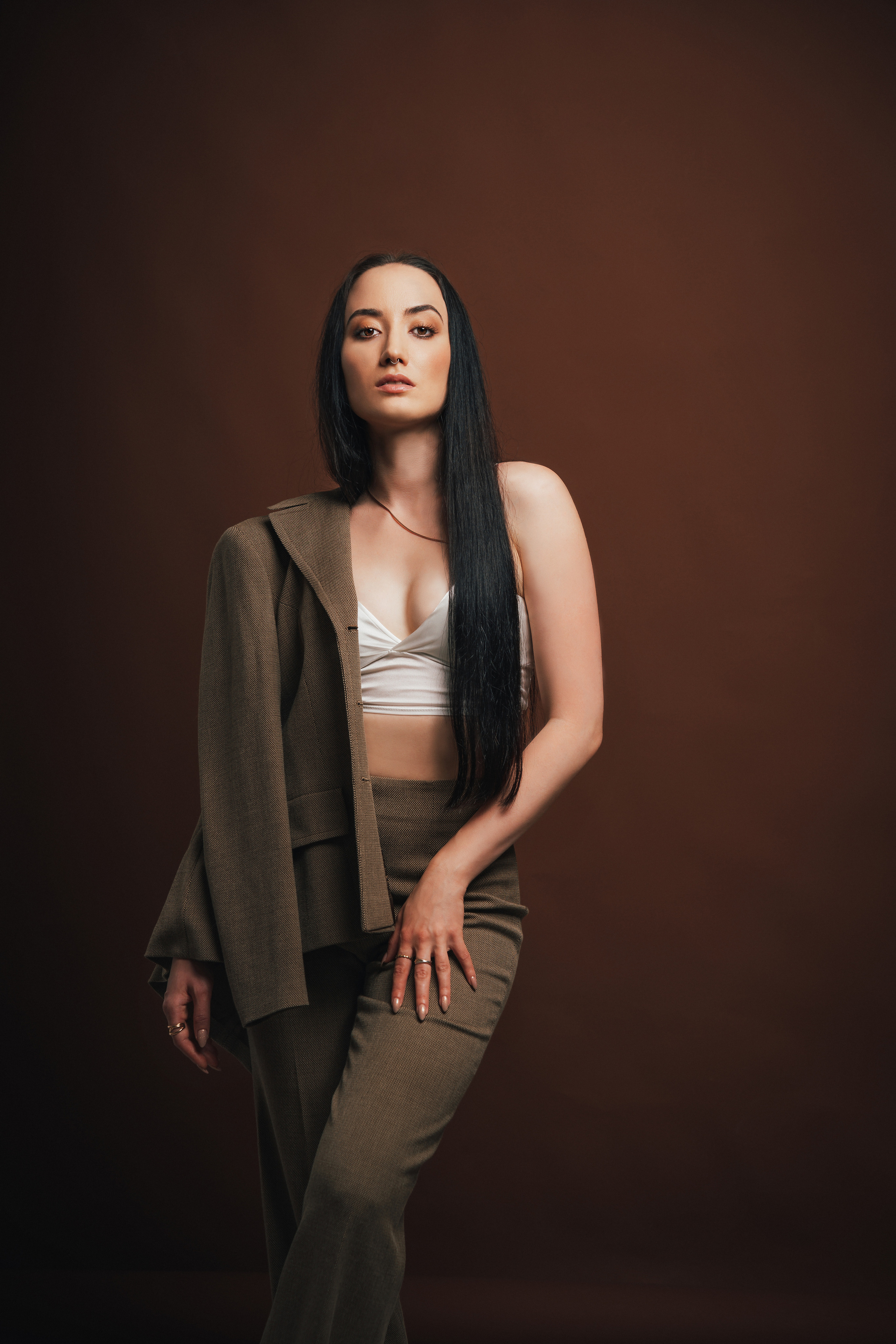 Фотоссесия в спб. Портрет красивой девушки в костюме на коричневом фоне. Фотограф спб