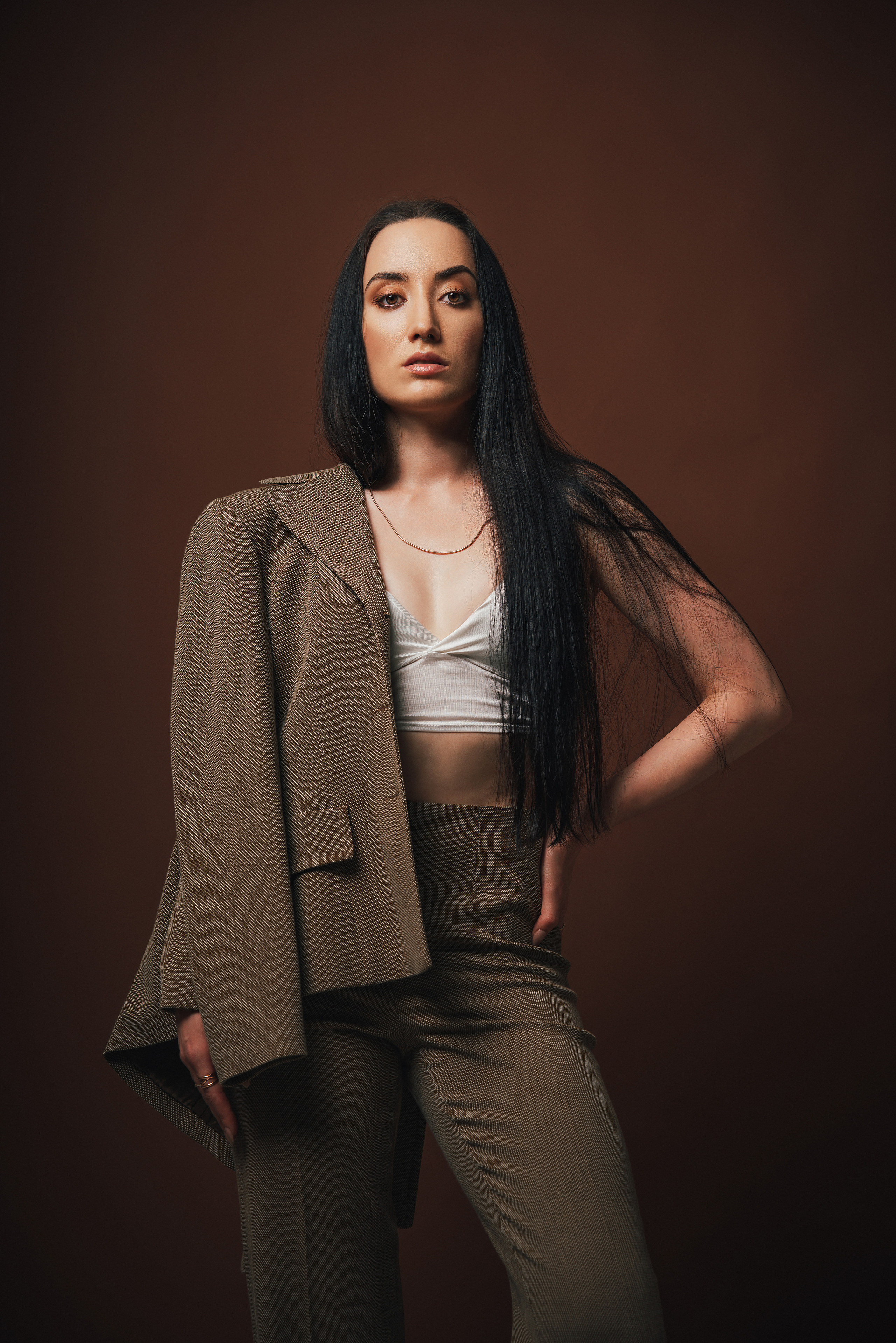 Фотоссесия в спб. Портрет красивой девушки в костюме на коричневом фоне. Фотограф спб