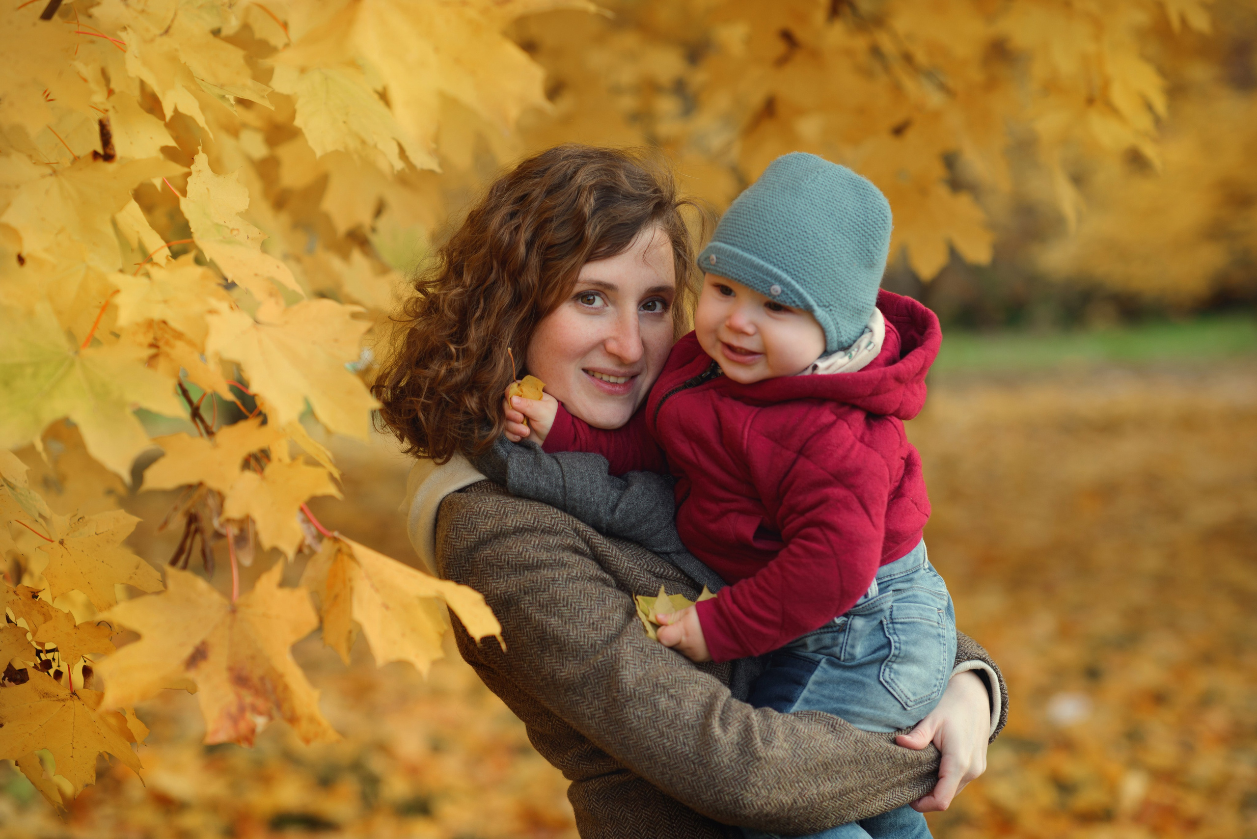 Photo shoot of a mom with baby in autumn. Photos with yellow leaves