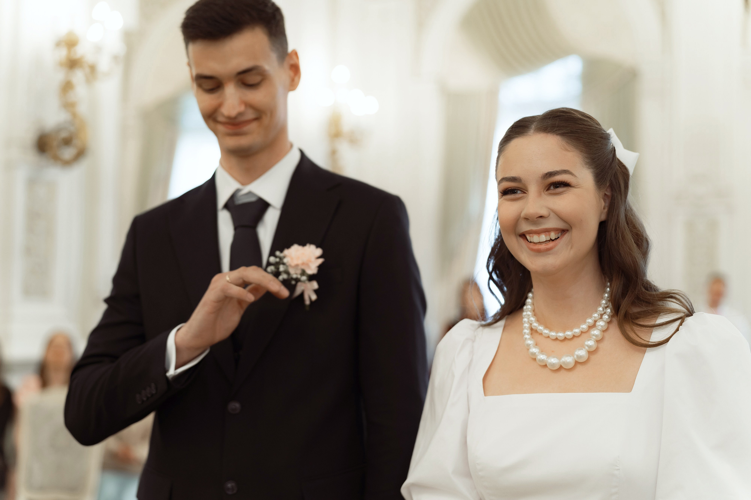 Счастливые жених и невеста улыбаются после обмена кольцами, торжественная свадебная церемония