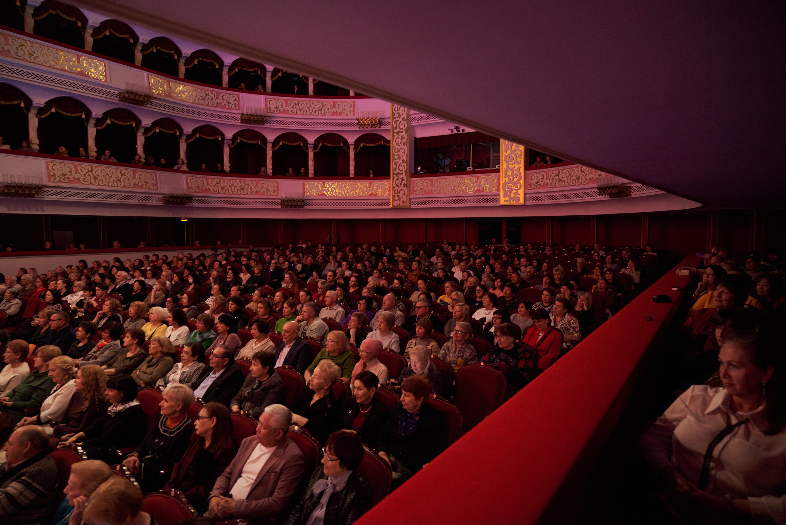 Публика в театре во время оперного концерта — приглушённый свет, внимание приковано к сцене