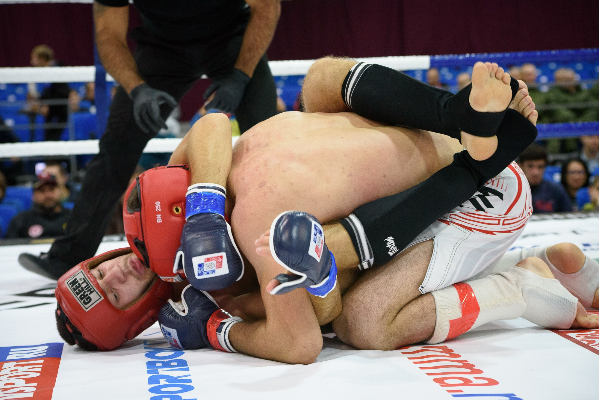 Спортсмены лежат на ринге во время схватки